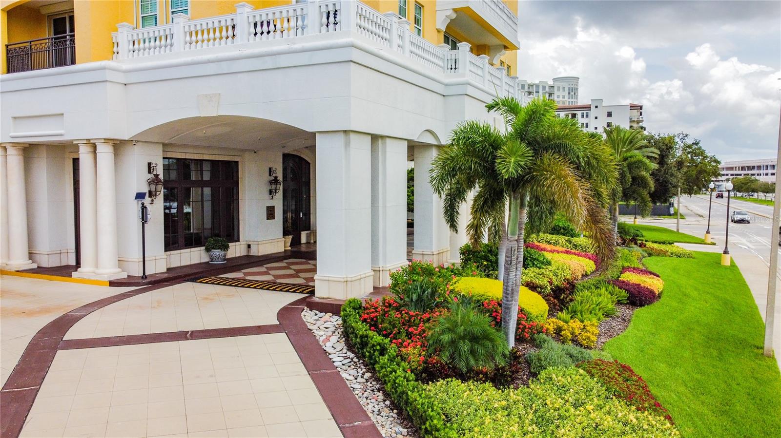 Elegant entrance with lush landscaping and grand architectural details.