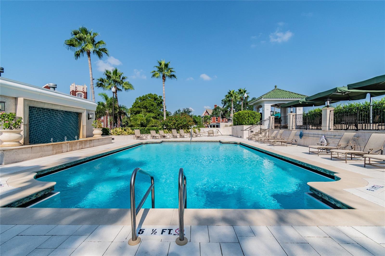 Resort-style pool with lounge seating and tropical landscaping.