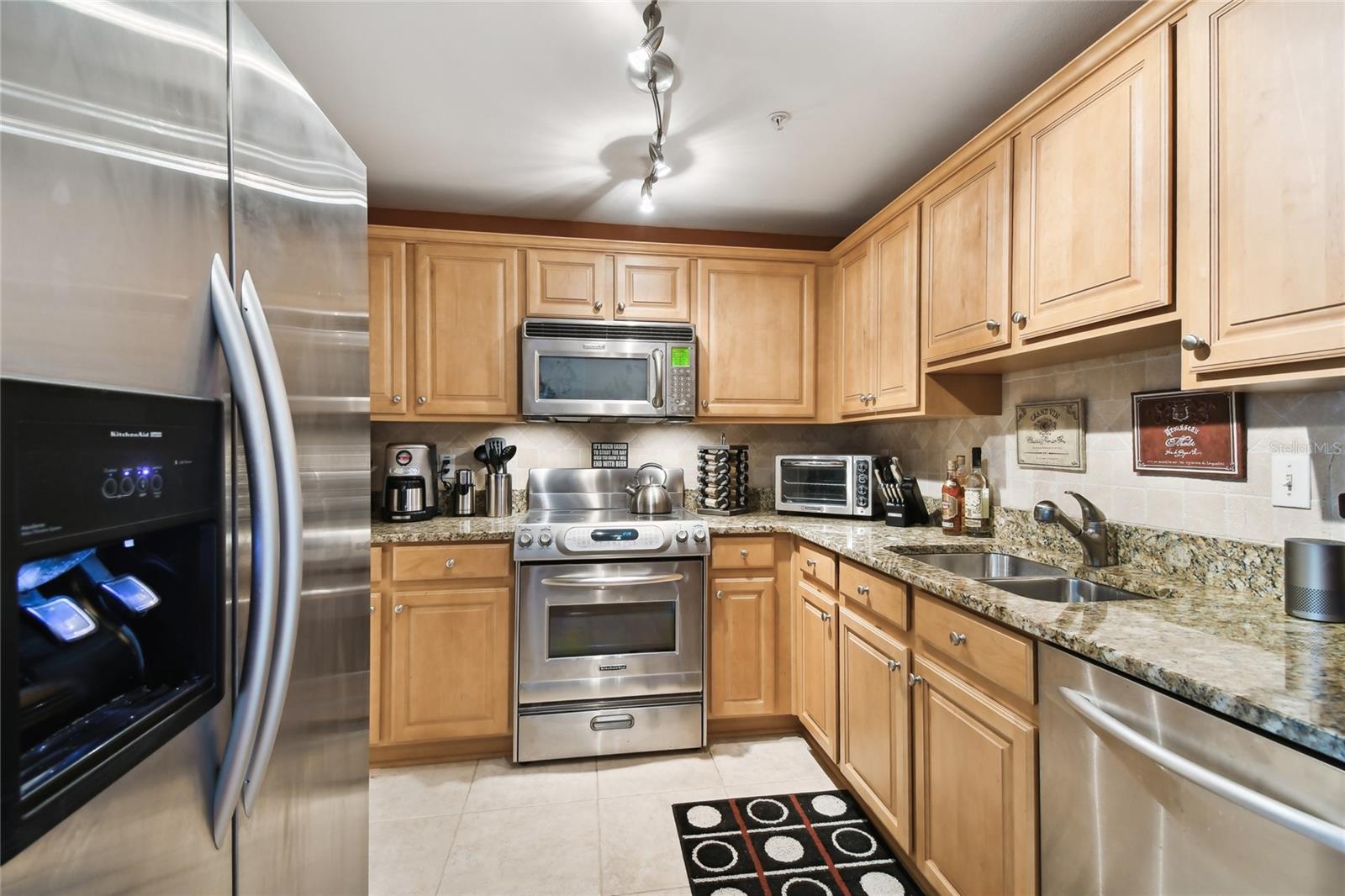 Modern kitchen with stainless steel appliances and granite countertops.