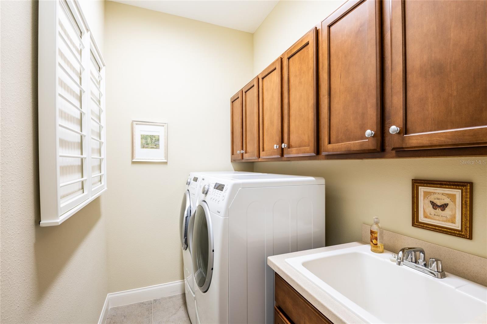 Laundry room includes washer, dryer, sink, built-ins