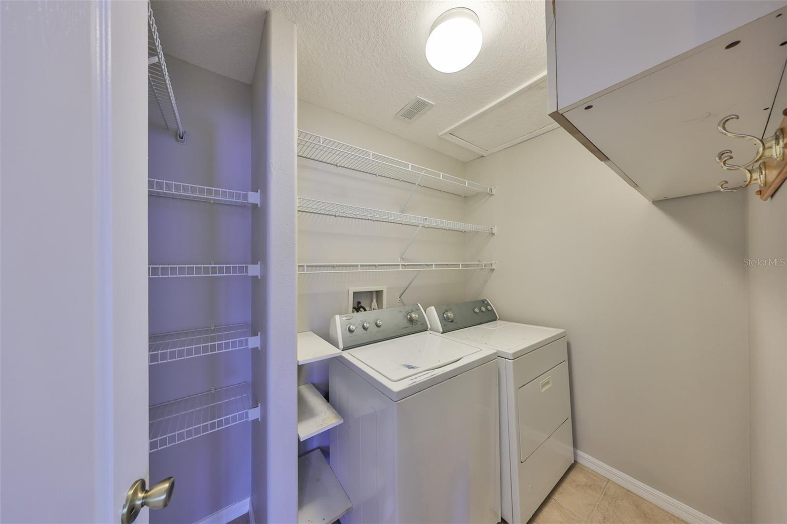 Laundry room has extra cabinets and a closet