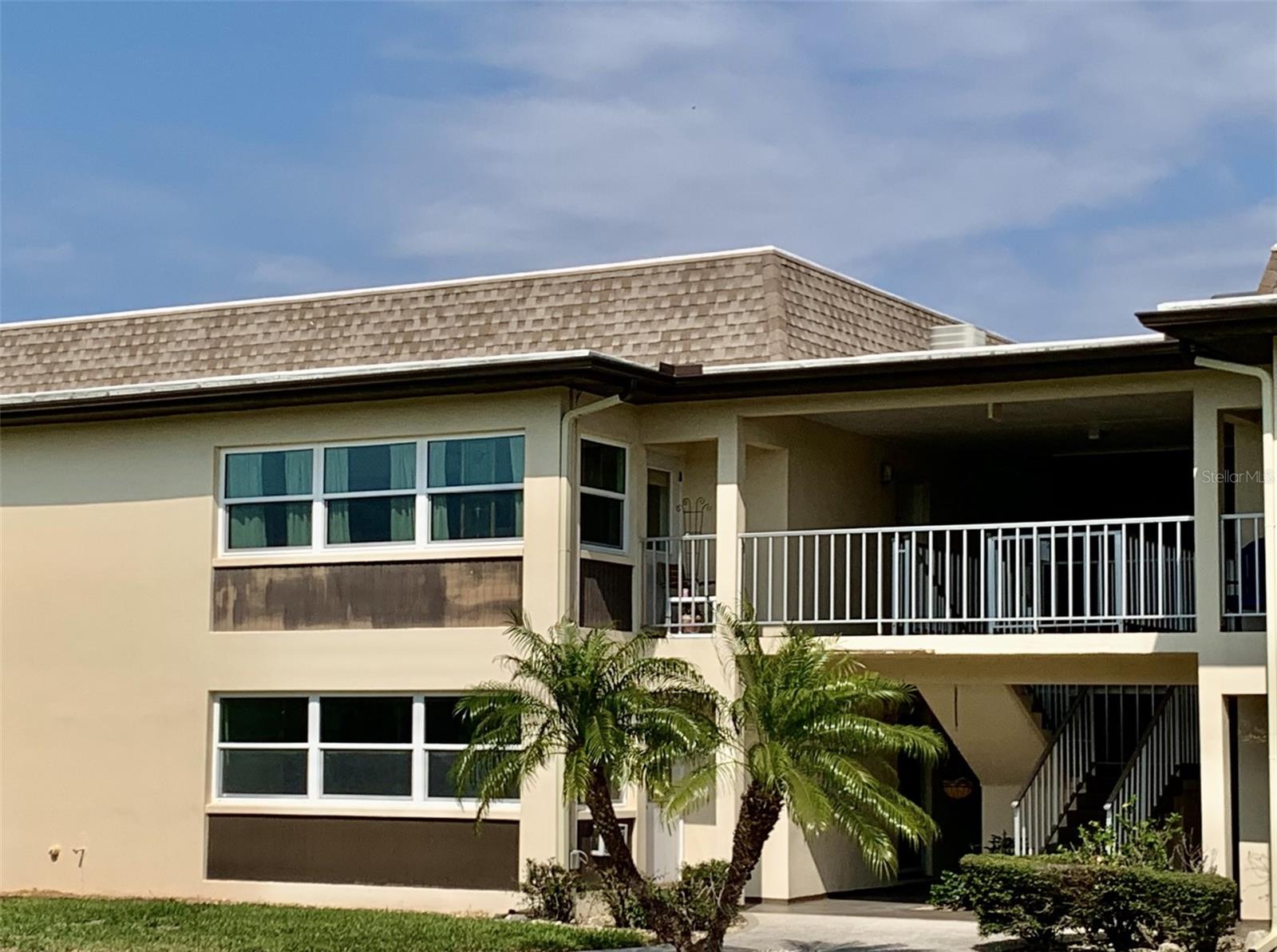 View of the condo from the back courtyard. Sunroom is upstairs windows