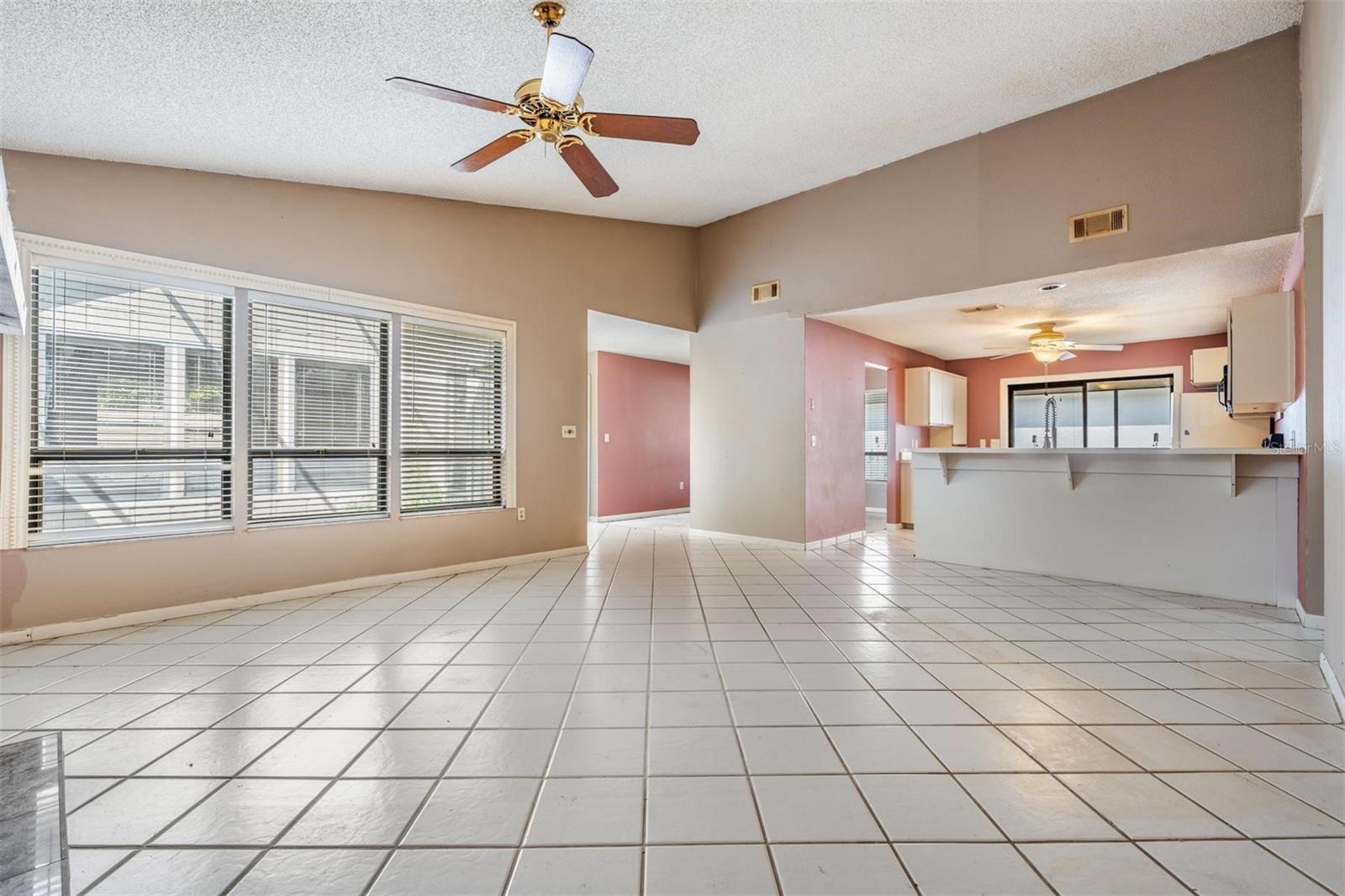 Family room with large windows for an abundance of natural lighting and a kitchen breakfast bar.