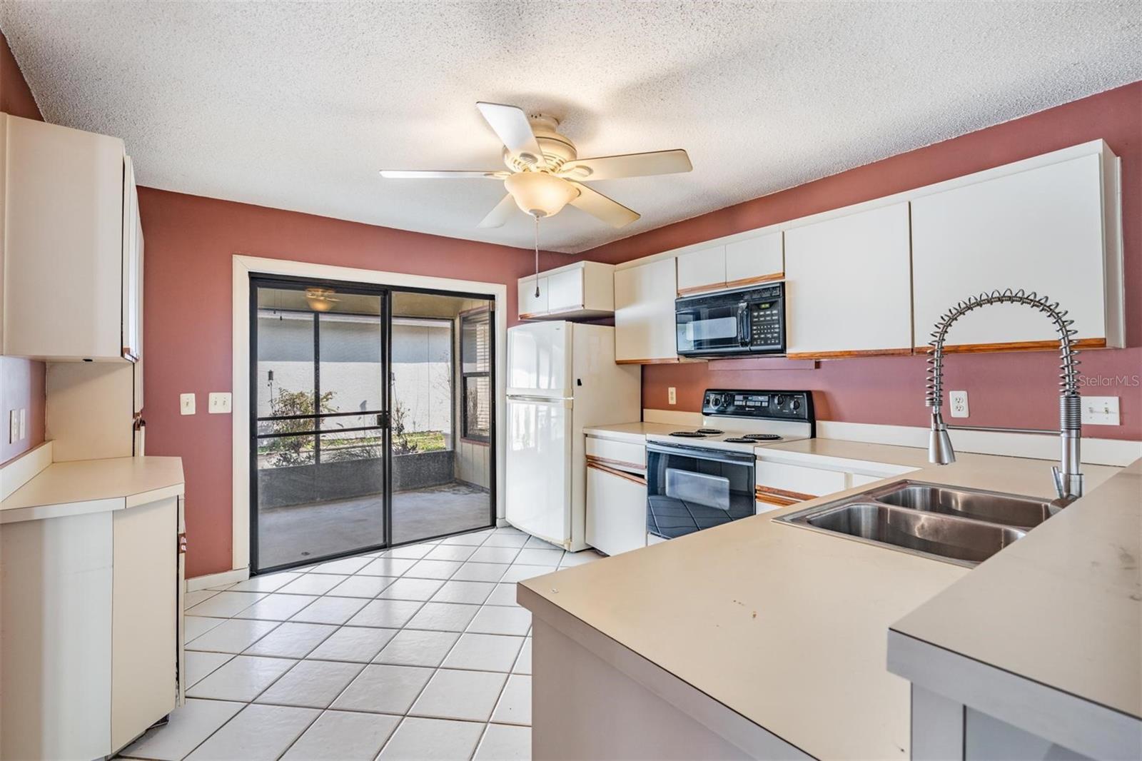 Kitchen opens out to screened patio and connects to the family room with elevated breakfast bar.