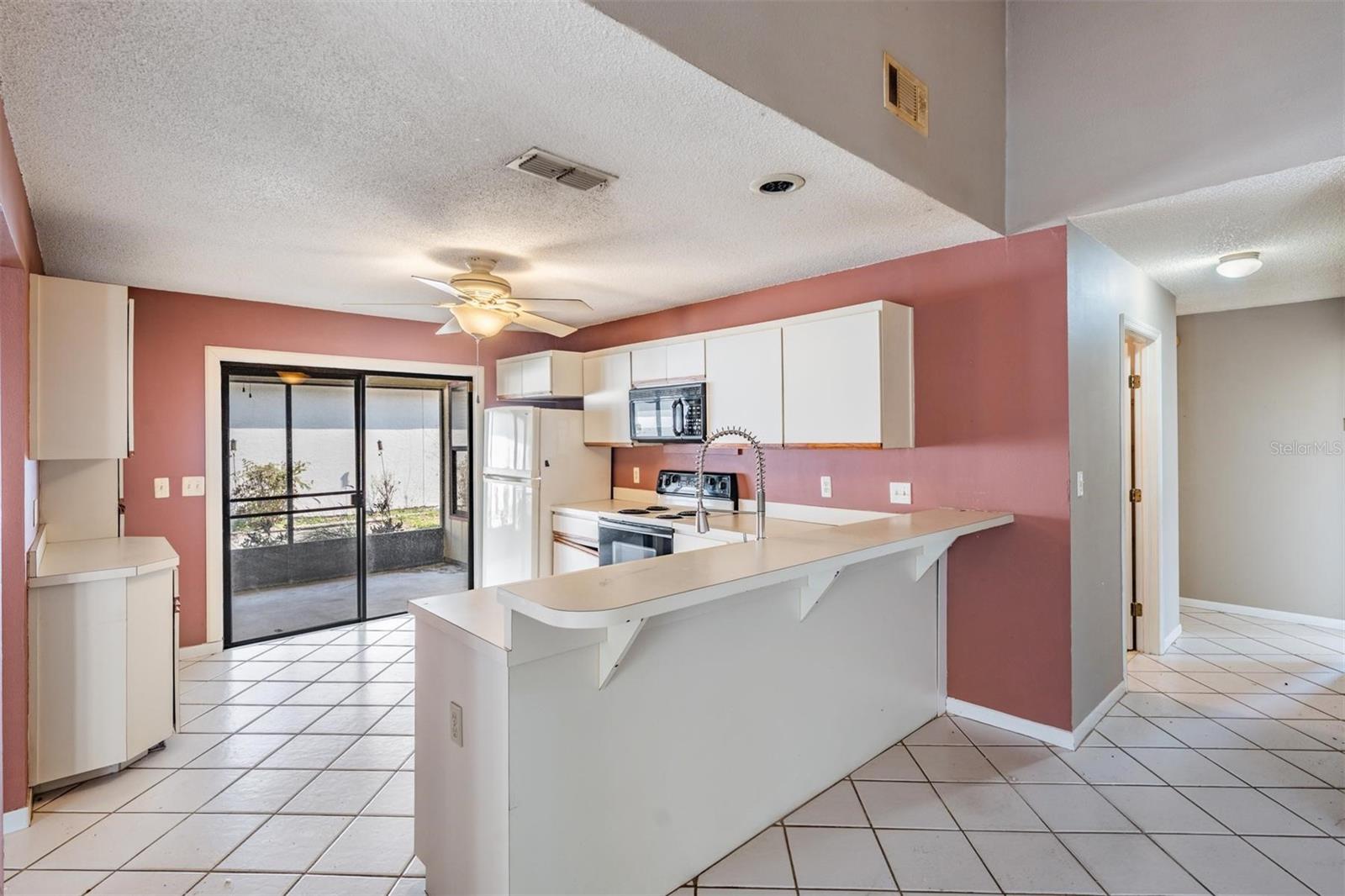 Kitchen opens out to screened patio and connects to the family room with elevated breakfast bar.