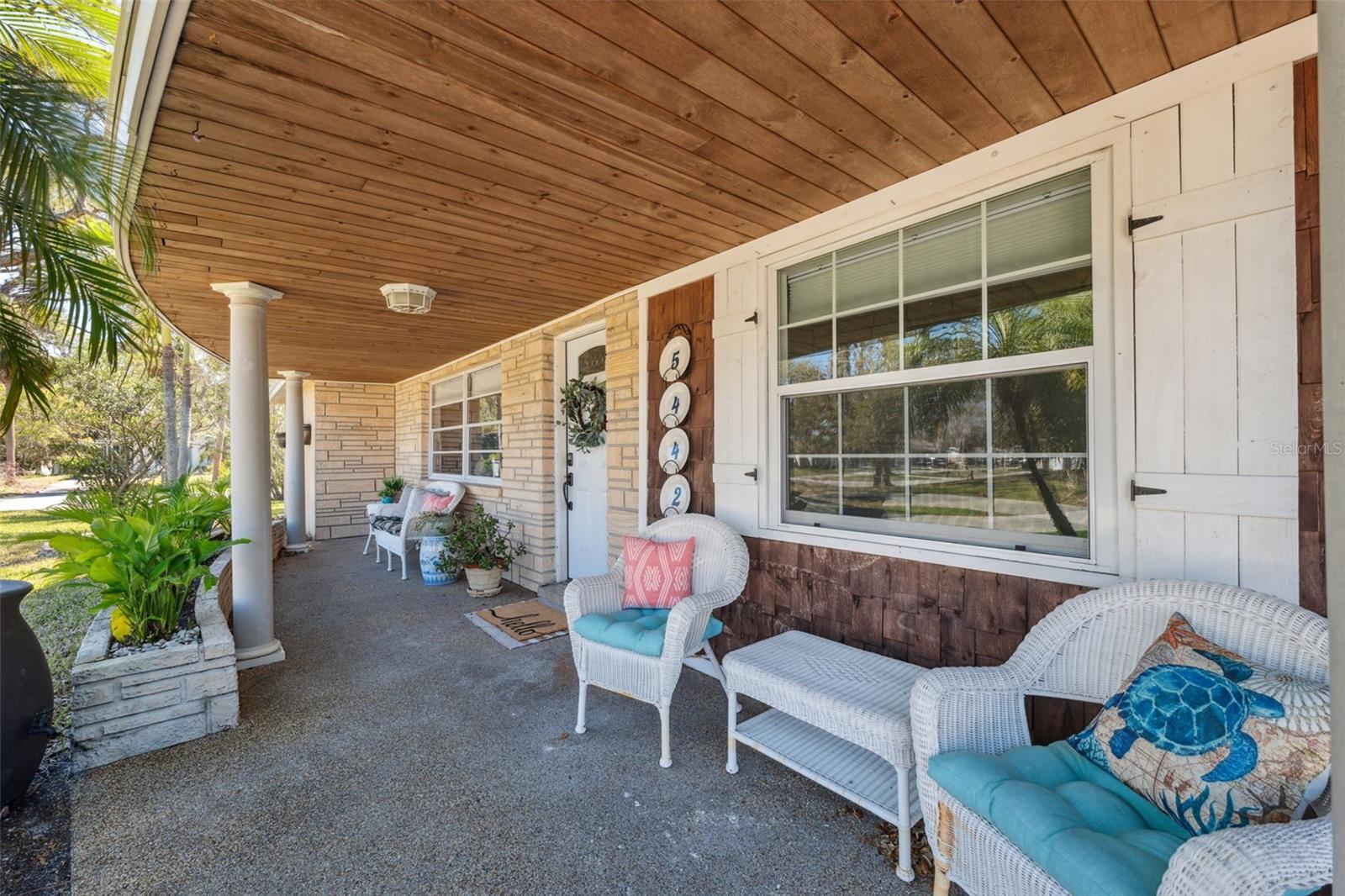 Front porch features shiplap wood ceiling