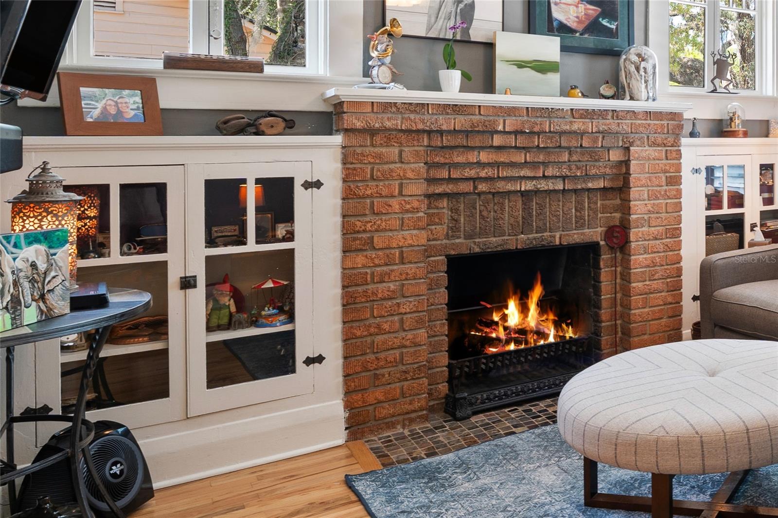 Original built-in cabinetry flanks the working fireplace