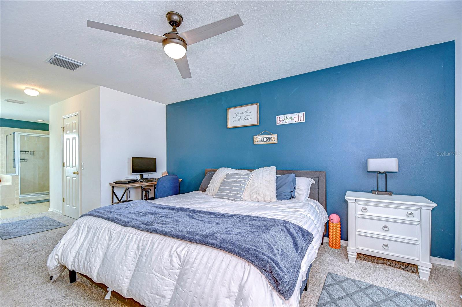 Discover tranquility in this delightful primary bedroom, featuring a charming accent wall and abundant natural light.