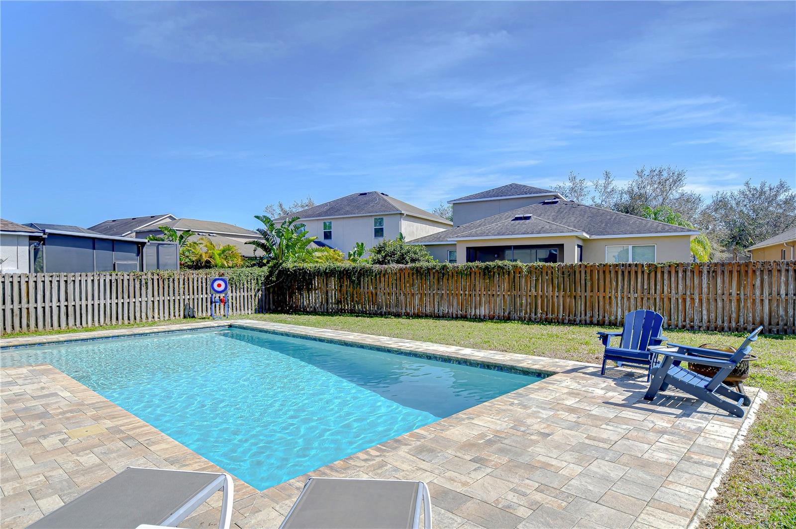 This backyard offers a pristine pool, perfect for cooling off on sunny days.