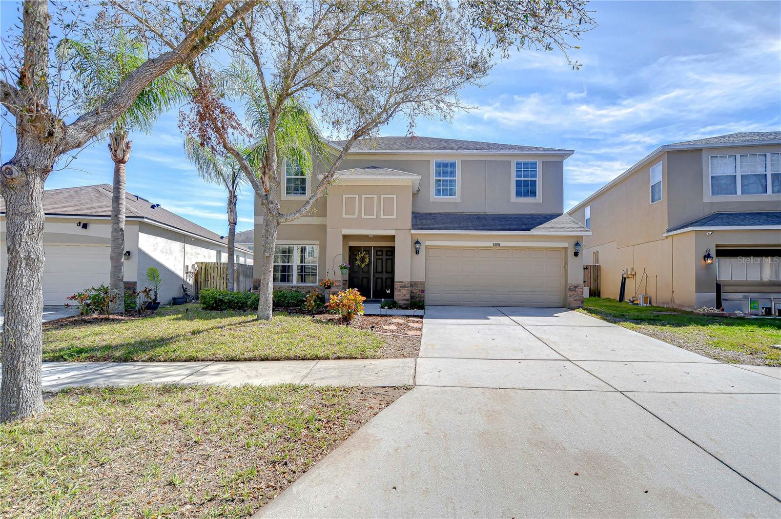 The mature trees and lush front yard create an inviting atmosphere.