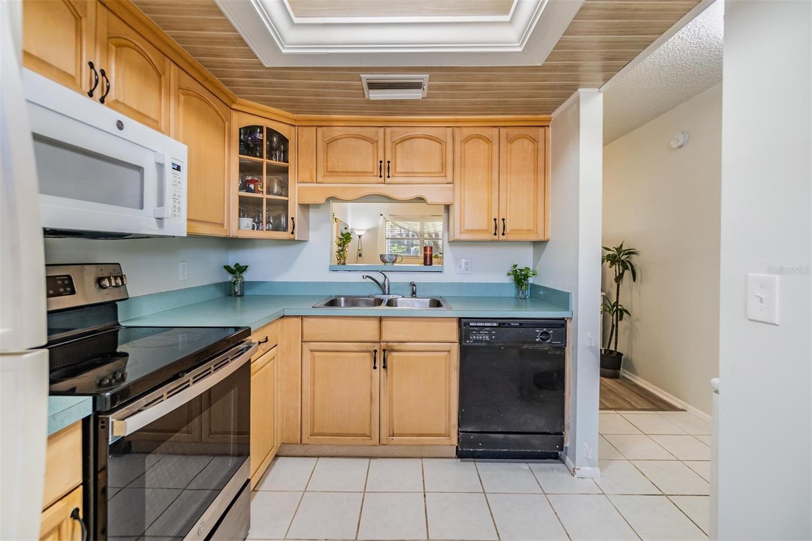 Kitchen is at the front of the home and features plenty of cabinets, counterspace and a passthrough window to the dining room.