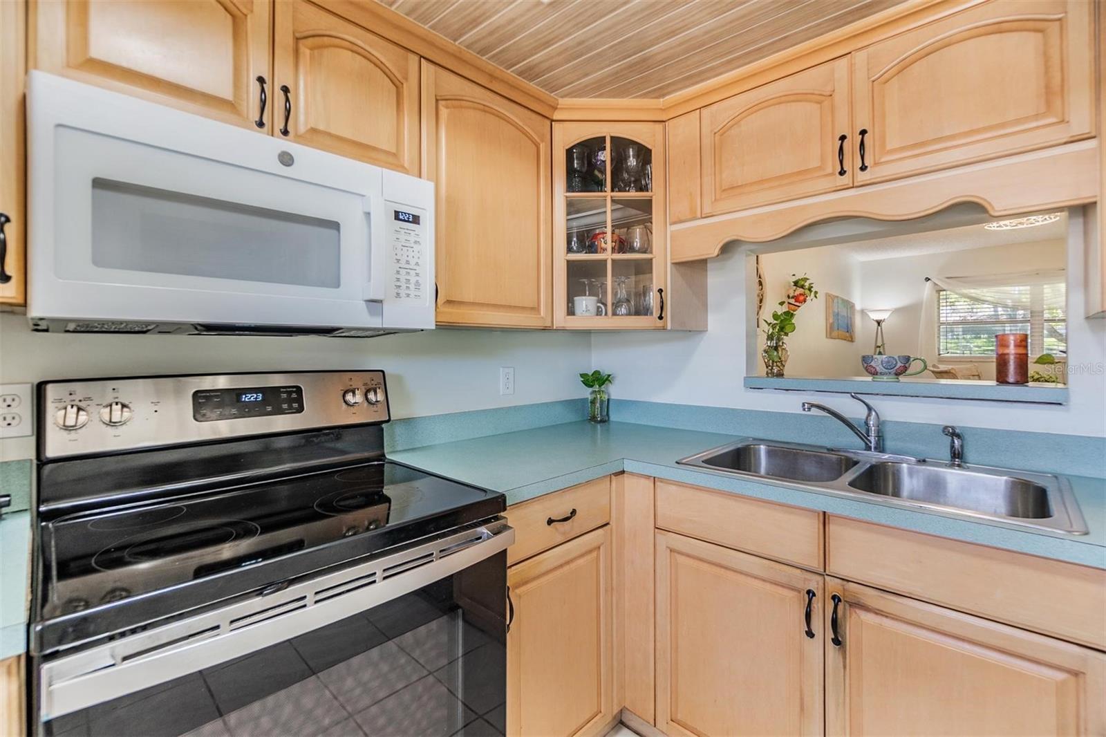Kitchen is at the front of the home and features plenty of cabinets, counterspace and a passthrough window to the dining room.