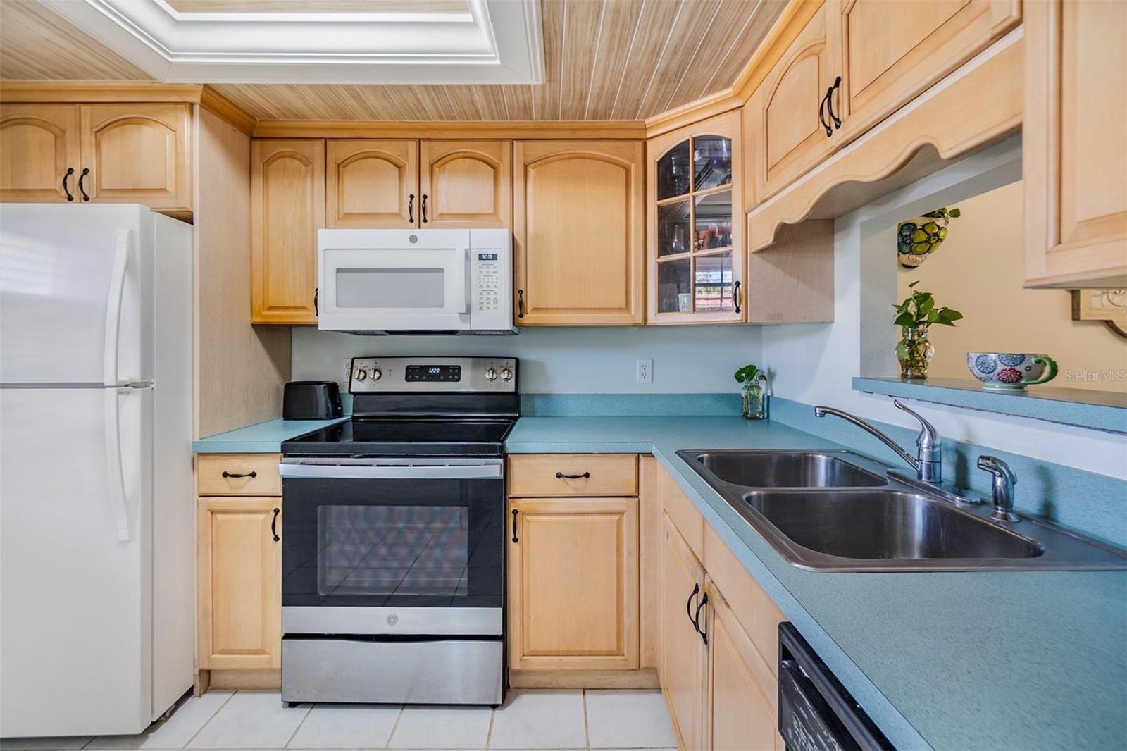 Kitchen is at the front of the home and features plenty of cabinets, counterspace and a passthrough window to the dining room.