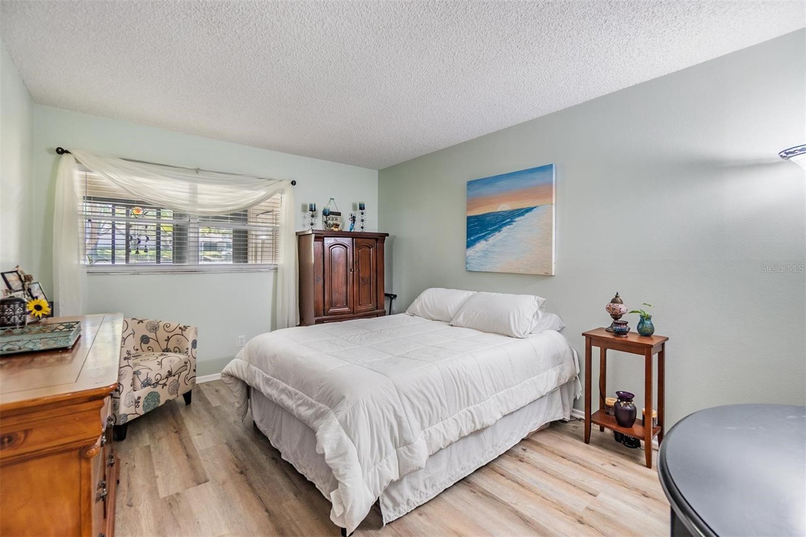 Nice sized bedroom with a walk-in closet, vinyl flooring, and window out to lanai and outdoor patio.