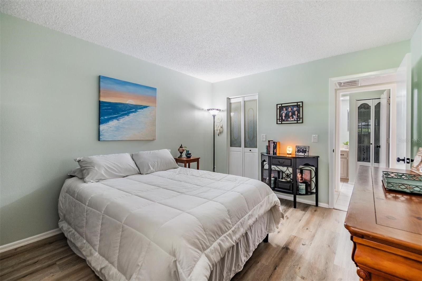 Nice sized bedroom with a walk-in closet, vinyl flooring, and window out to lanai and outdoor patio.