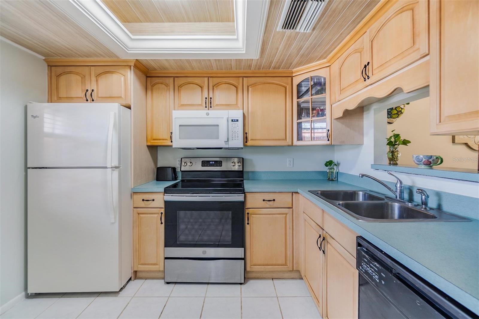 Kitchen is at the front of the home and features plenty of cabinets, counterspace and a passthrough window to the dining room.