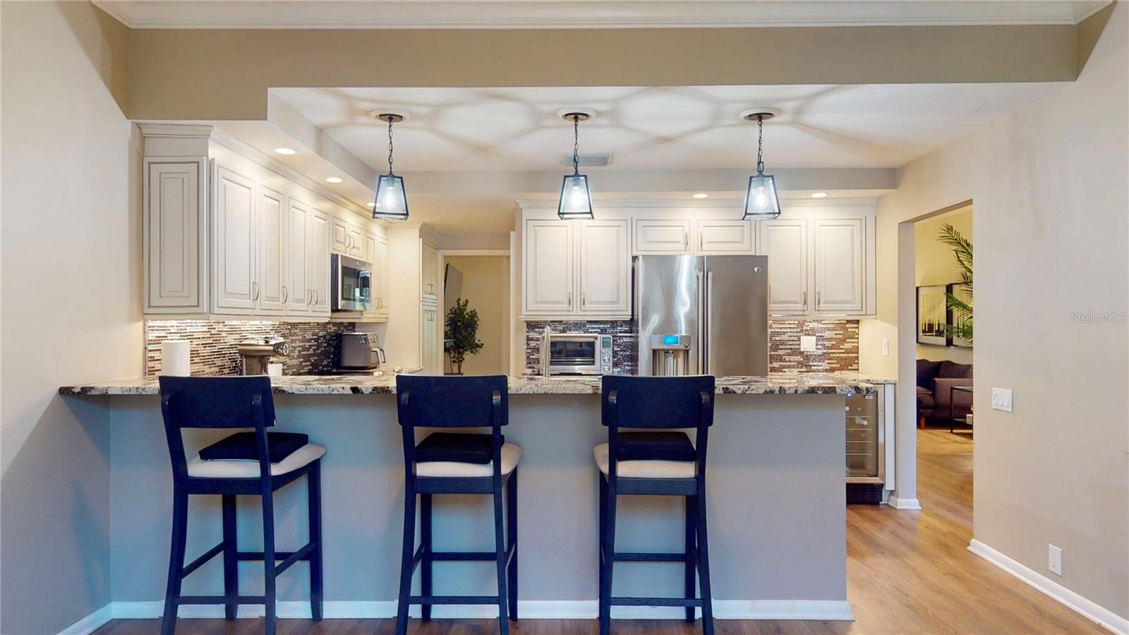 Barstools at the kitchen counter, viewed from the back of the dinette area.