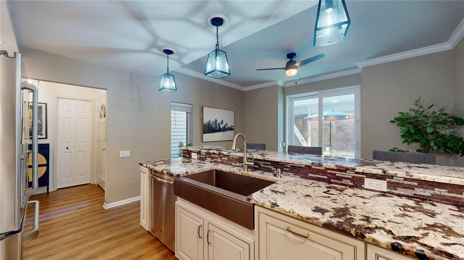 Kitchen looking toward the front foyer and the front courtyard out the sliders.(with hurricane shutters)