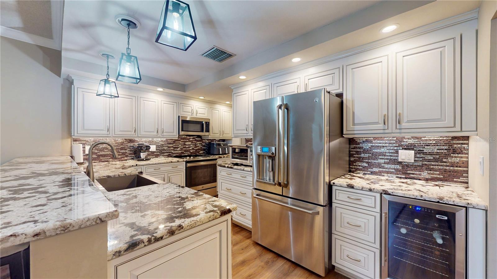 Another kitchen view showing counters, cabinets, drawers, and a wine cooler