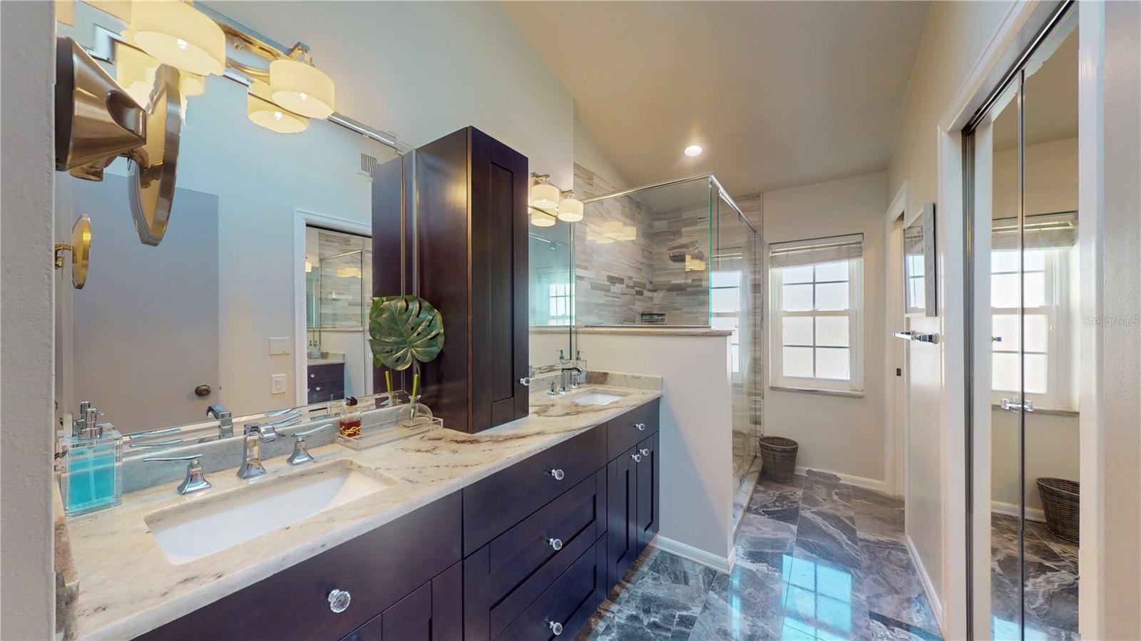 Primary, ensuite bath with marble floors, dual sinks, walk-in shower, and walk-in closet.