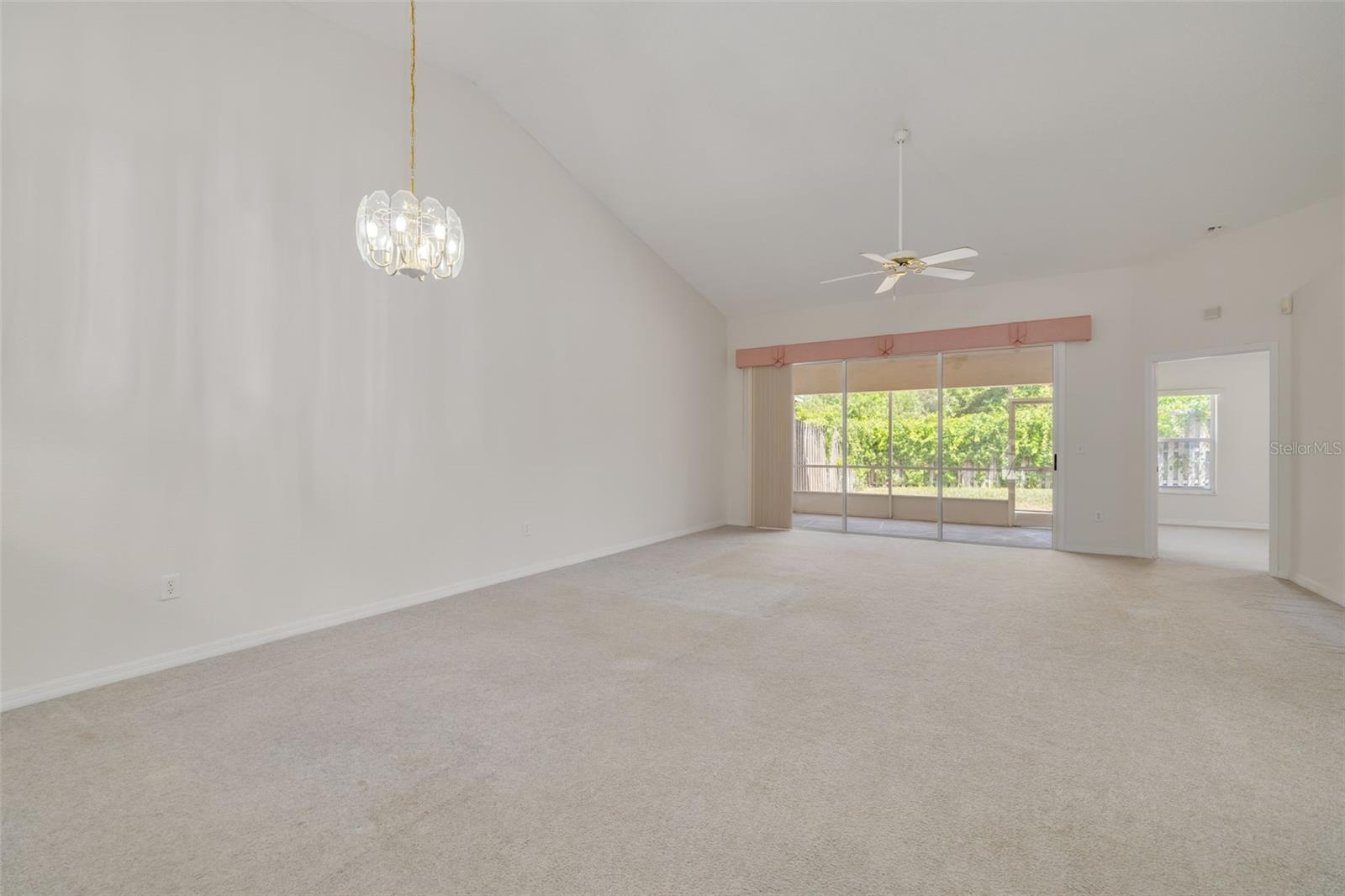 Large living/dining room with sliders our to screened porch