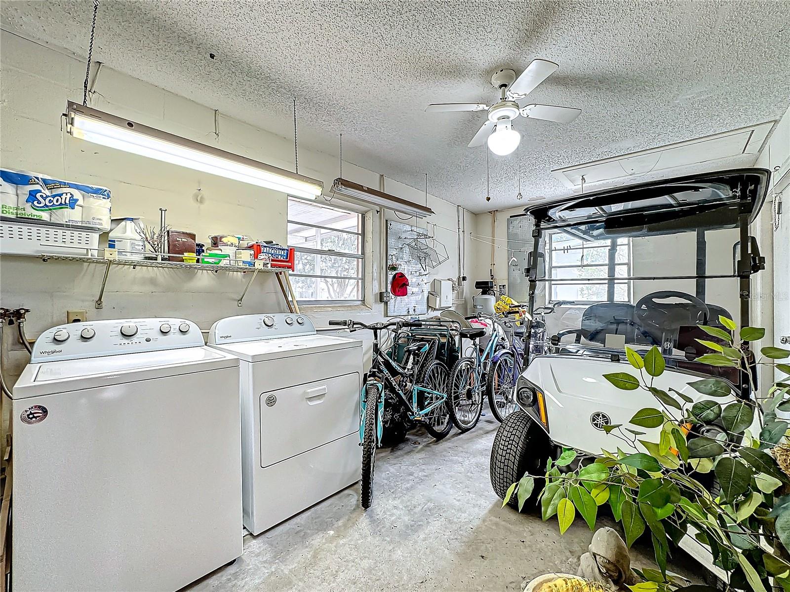 Storage room with laundry and space for golf cart.