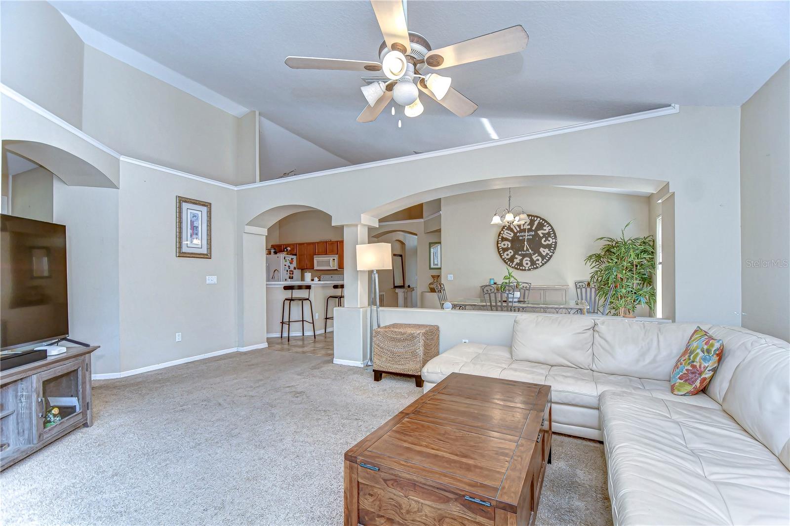 Step into relaxation in this airy living room with its high ceilings and welcoming arches, seamlessly flowing into the cozy dining area.