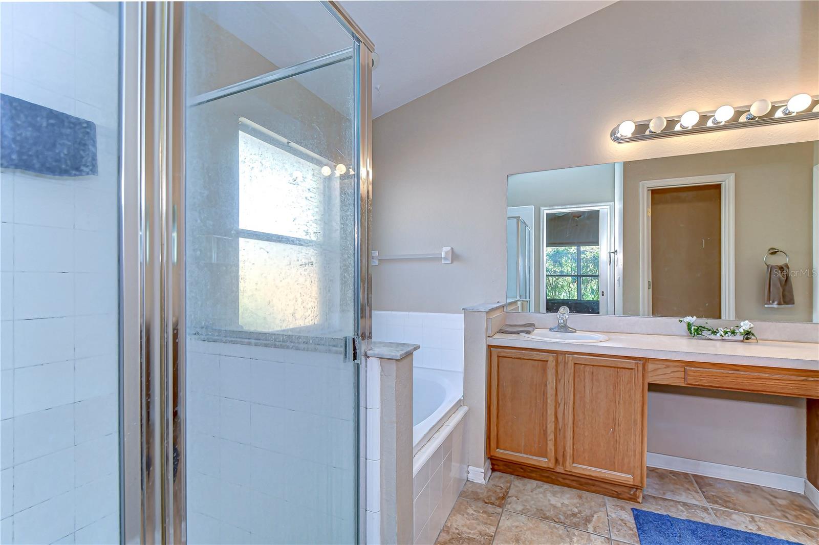 Step into your serene retreat with this spacious bathroom, boasting a spacious  shower and inviting bathtub perfect for relaxation.