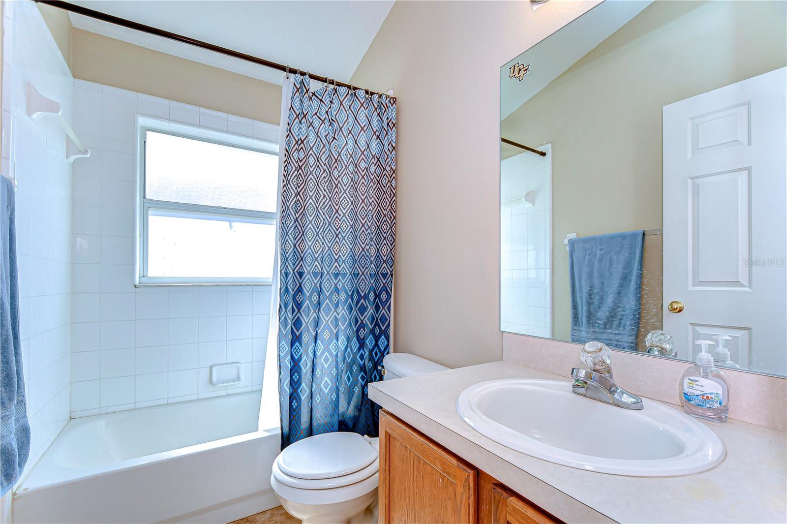 Step into this bright and inviting bathroom, where natural light streams through the window, creating a relaxing ambiance.