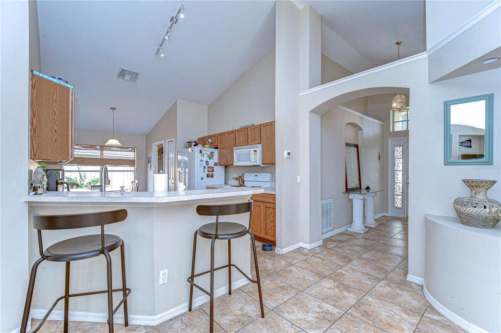 Step into this welcoming kitchen, where high ceilings meet ample natural light, setting the stage for both casual breakfasts and grand culinary adventures.