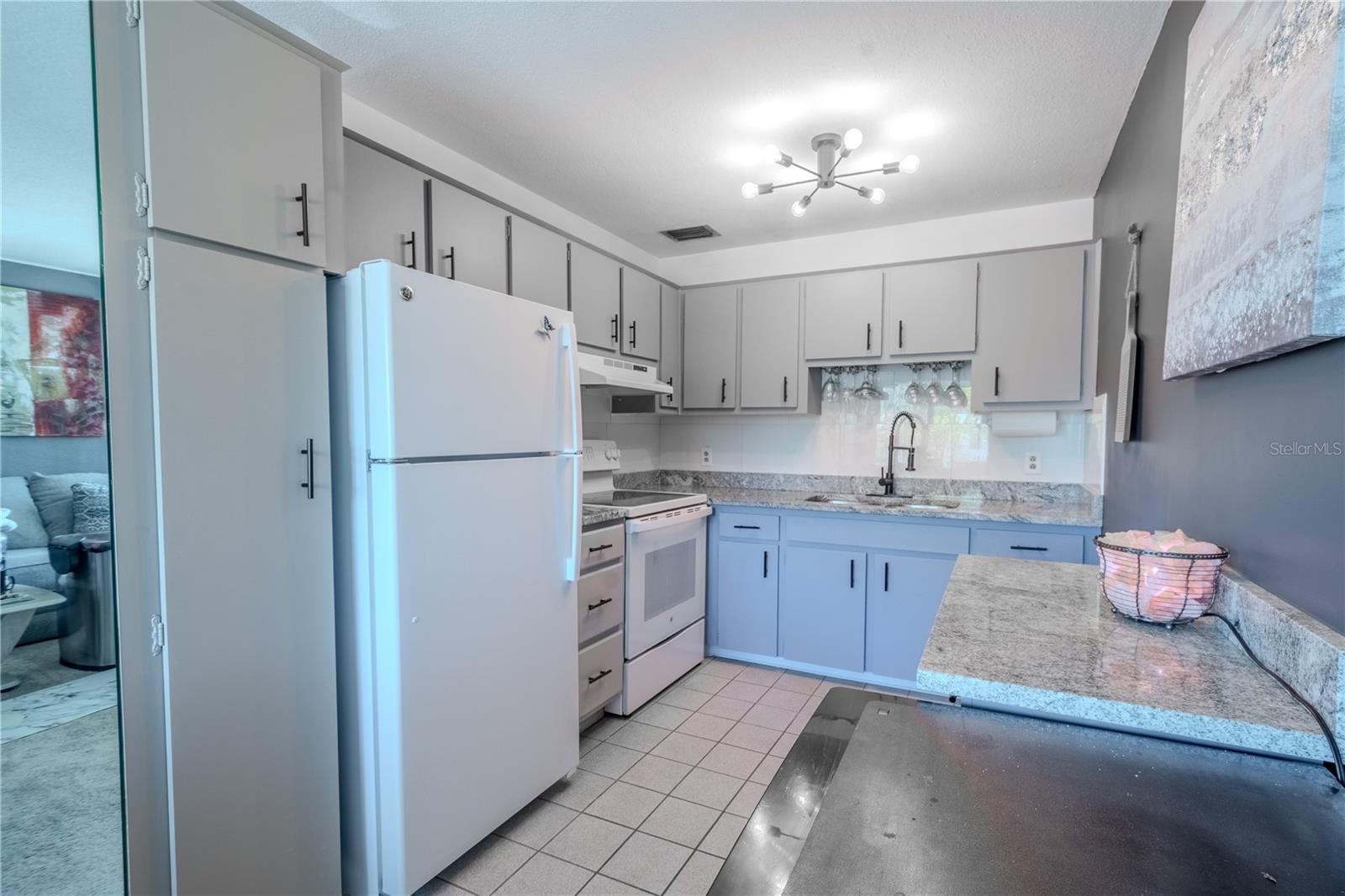 The kitchen features a counter and cabinet ideal for a coffee and food prep station, and a beverage refrigerator.