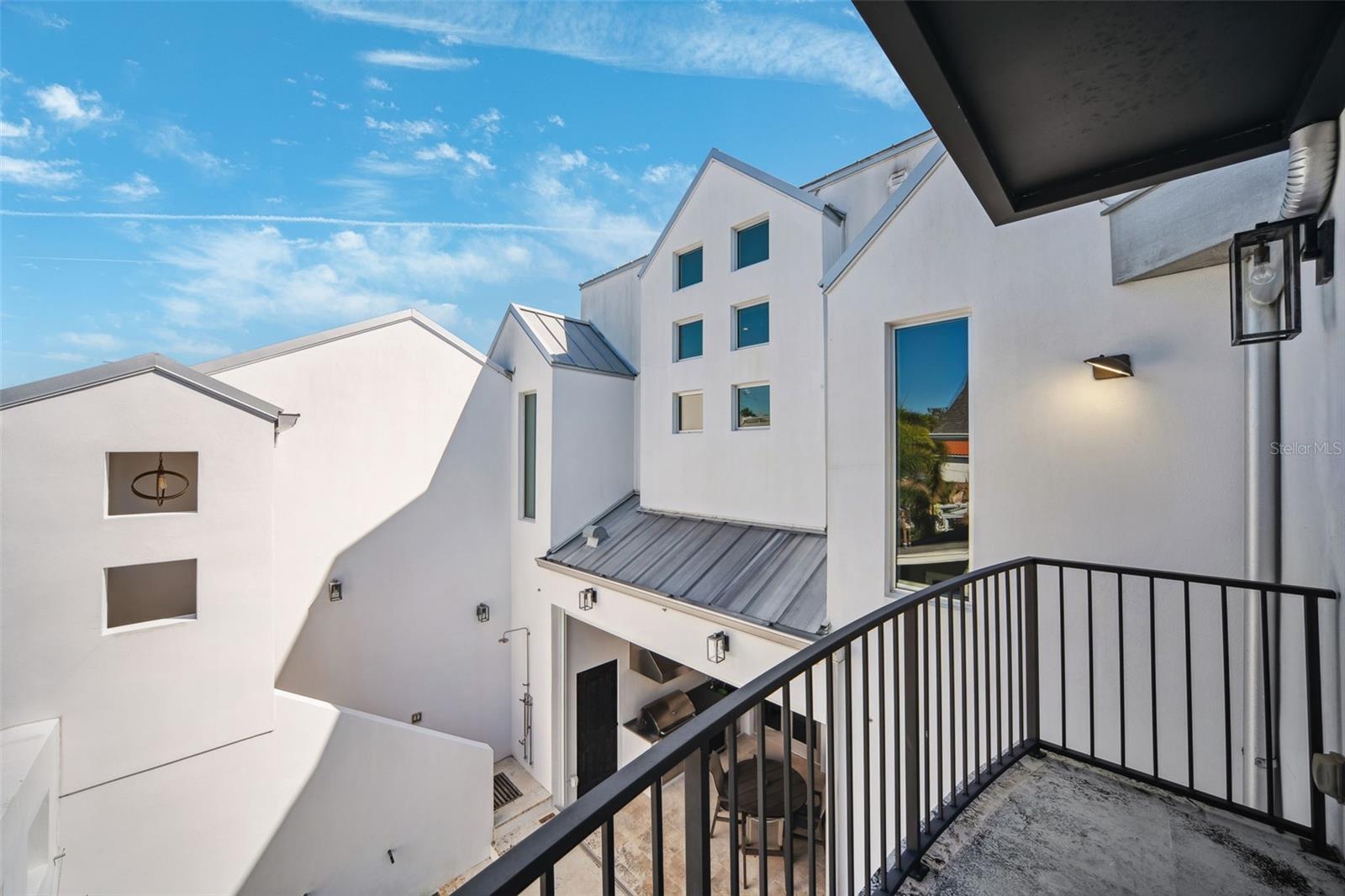 Juliet balcony in Primary Suite overlooks pool area.