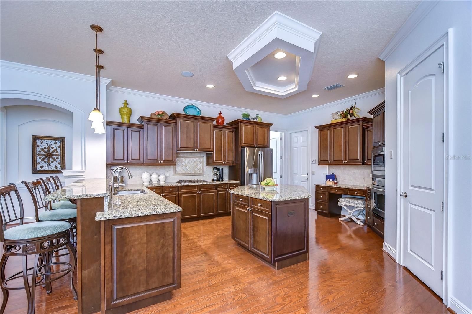 Boasting rich wood cabinetry, sleek granite countertops, and charming pendant lighting, it’s perfect for both weekday dinners and entertaining guests.