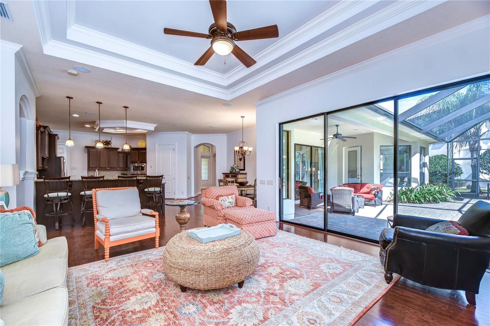 Step into elegance with this open-concept living area, where natural light dances through expansive glass doors.