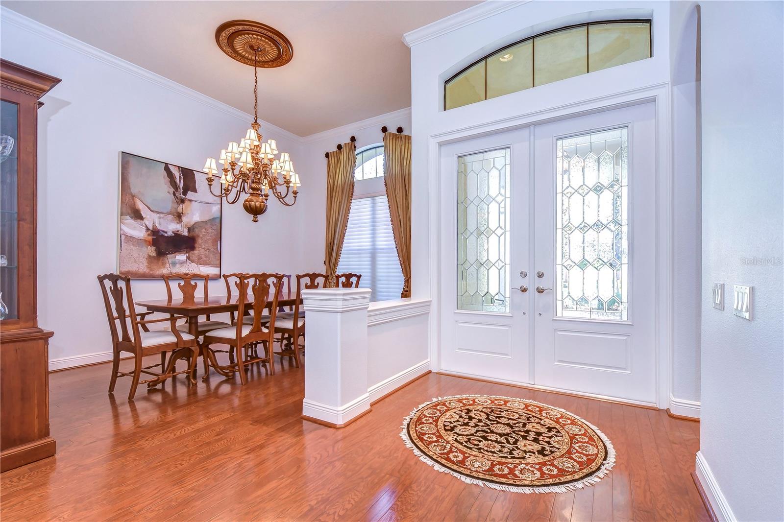 Step into elegance with this charming entryway and dining room, where the grand chandelier sets a tone of sophistication.