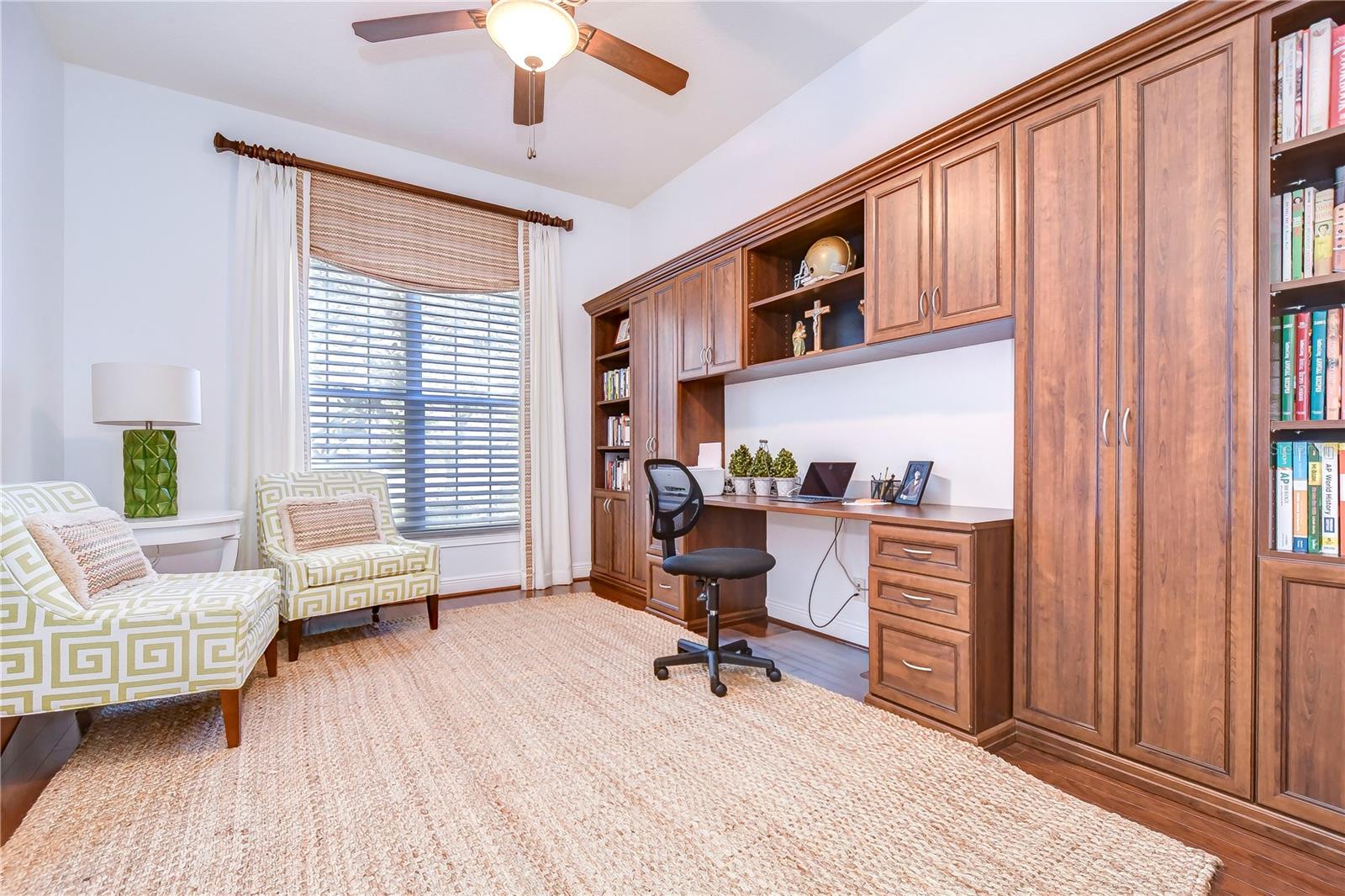 This bright and inviting space features custom wooden cabinetry and a sleek work desk, offering both style and function.