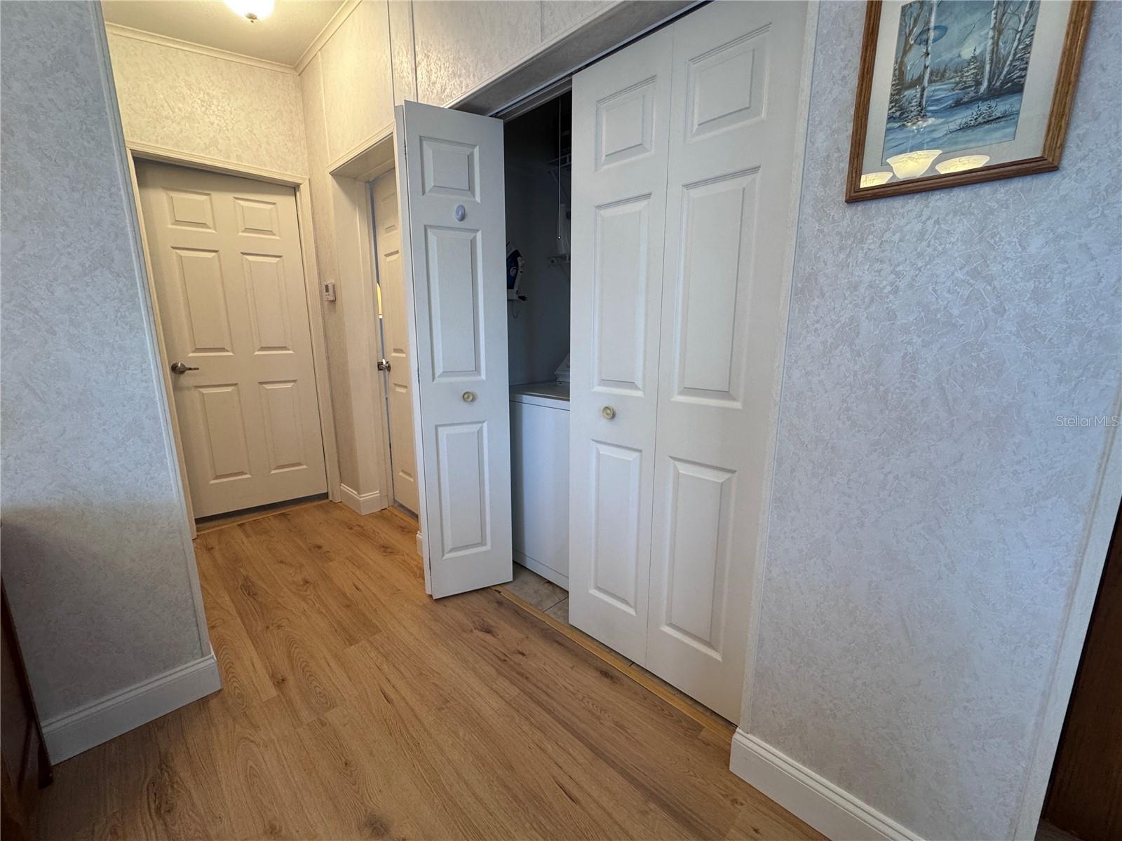 Hall laundry closet with washer and dryer.