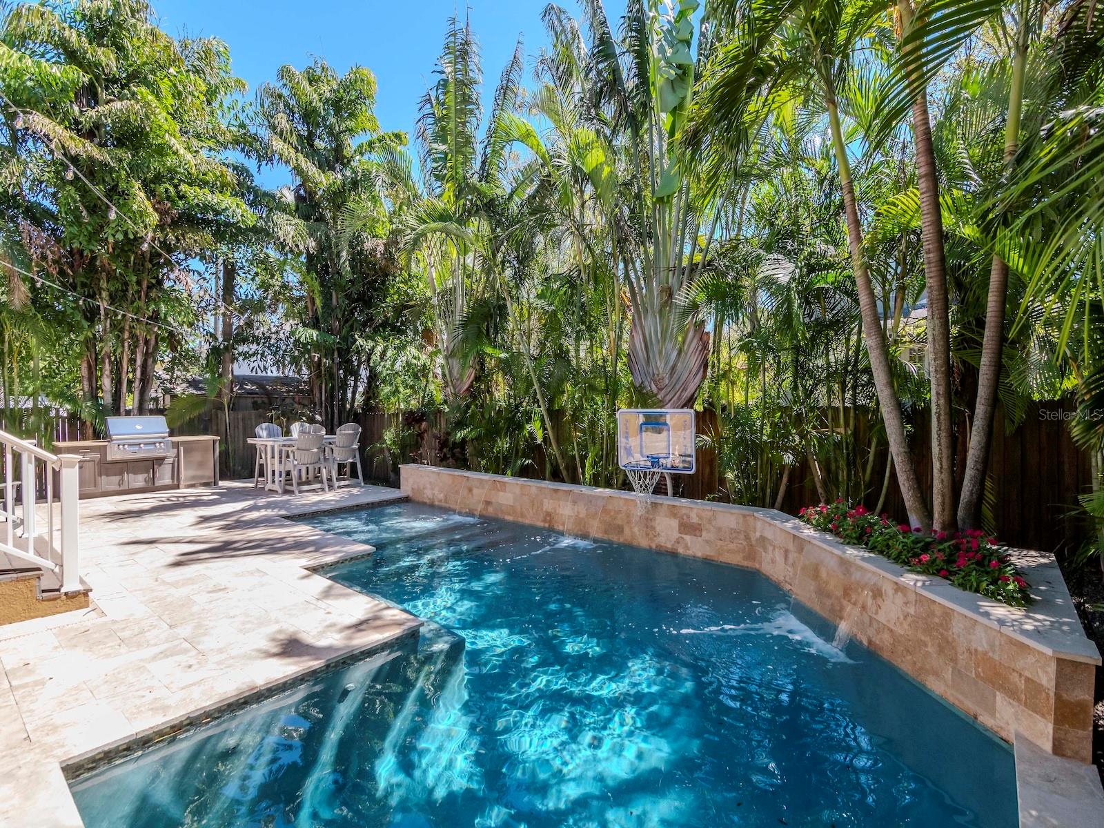 Open pool with lounging area, travertine deck