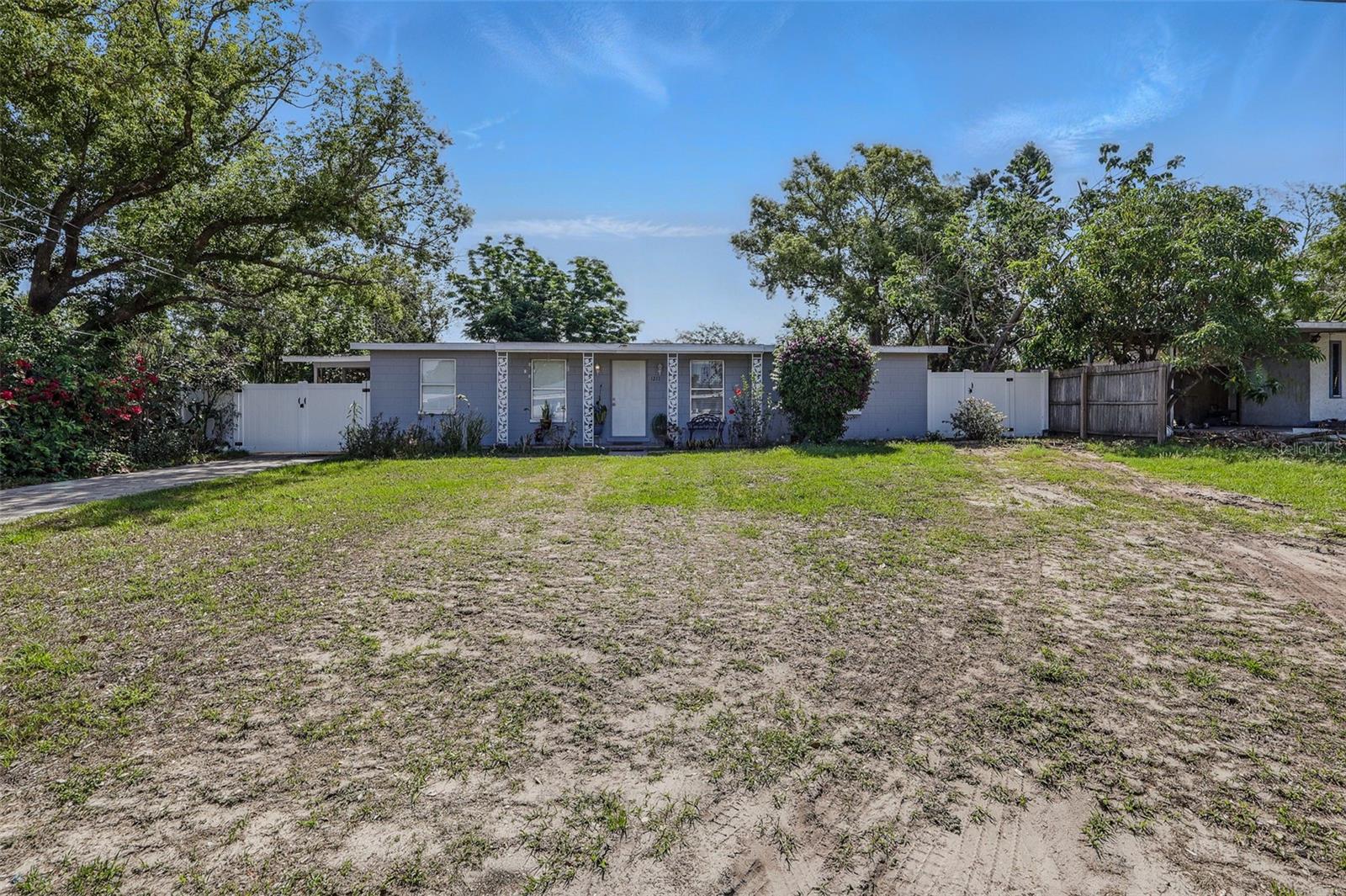 Front View, carport on left side behind the fence.