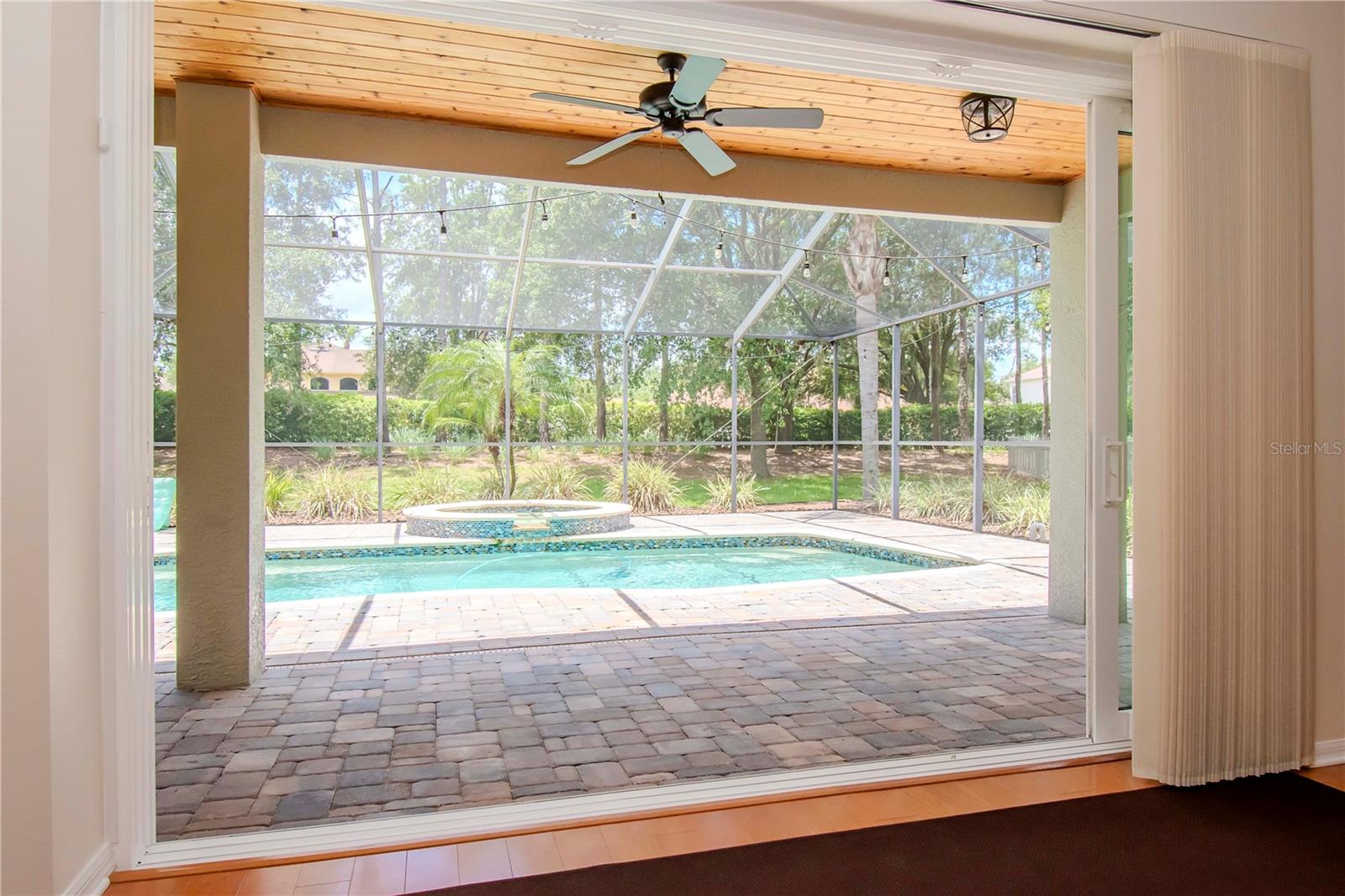 View of lanai and pool. Custom wood ceiling.