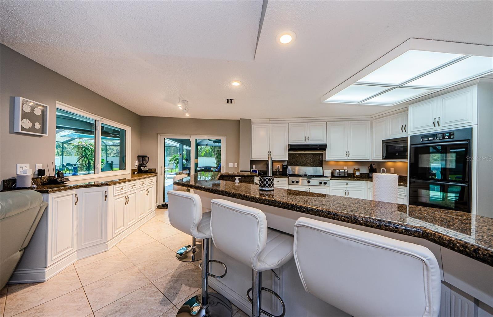 Great view of kitchen, buffet, sliding doors out to pool area.