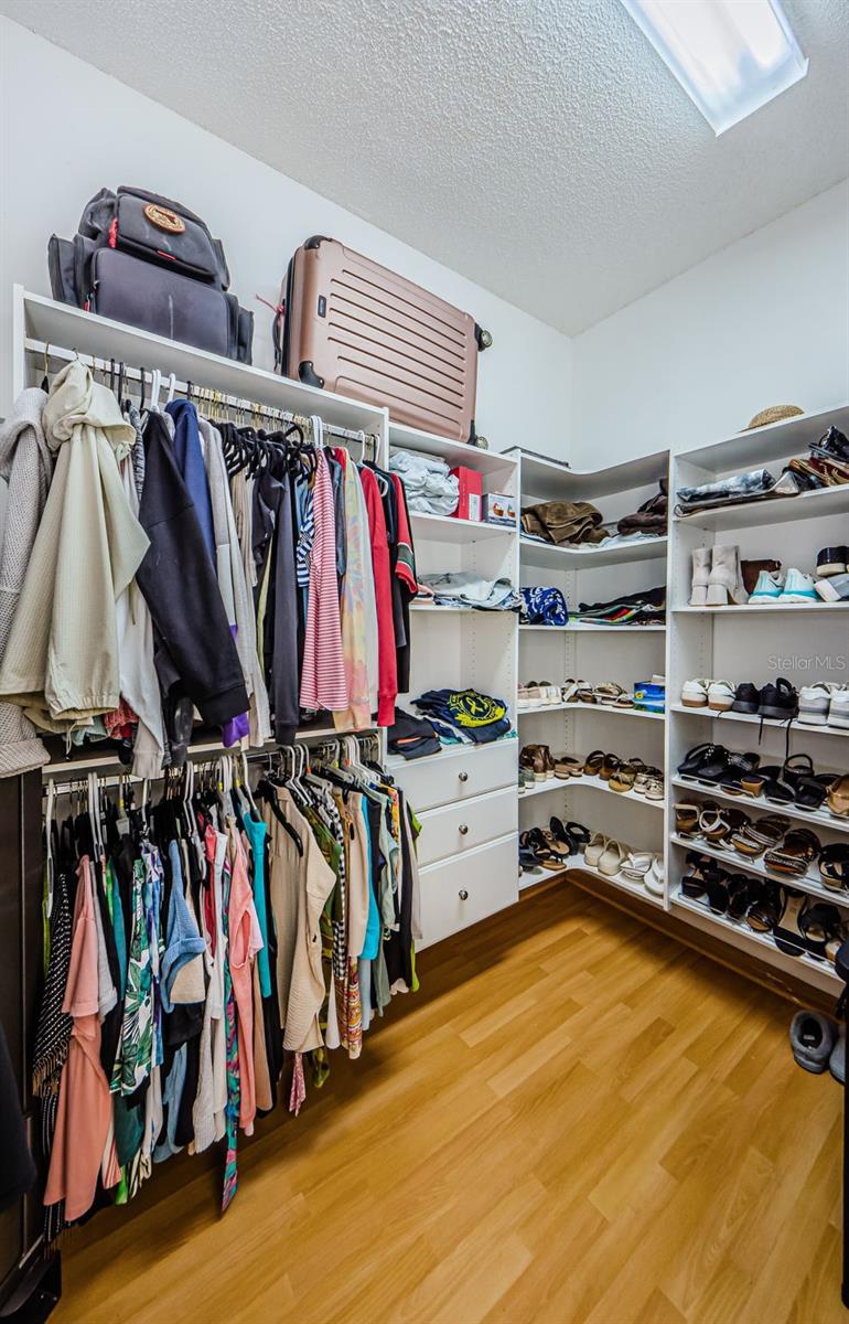 Large Walk-in Closet in Primary Bedroom Suite for her, Shelves for folded clothes, and drawers.  Plenty of shelves for shoes.