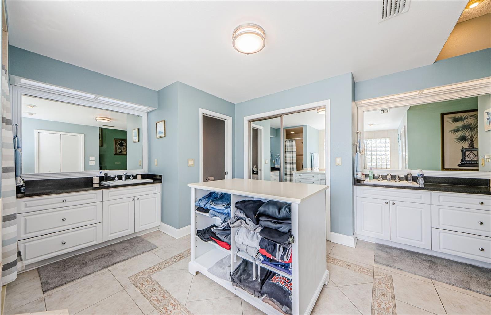 His and Hers preparation vanities and separate closets.  Clothing vanity in middle for him. Drawers on other side.