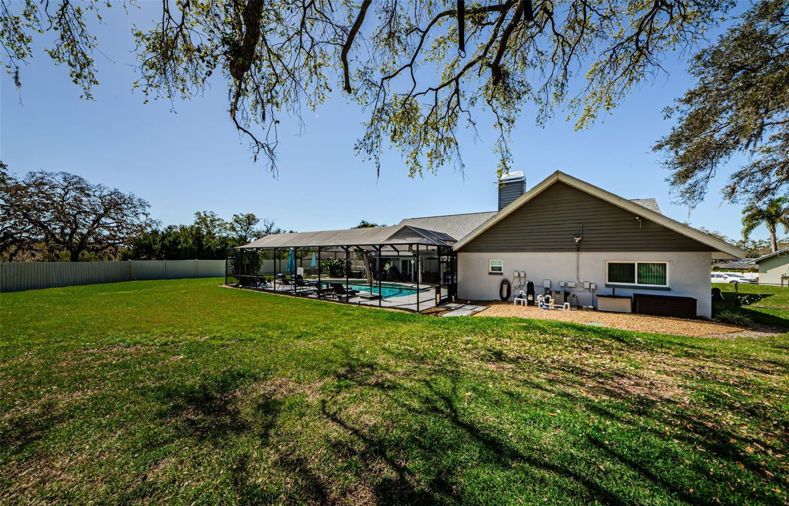 Backyard with view of pool!  New pool pump installed, gas pool heater installed, new pool cage led lighting installed, new child guard pool safety fence installed, new spa light installed.