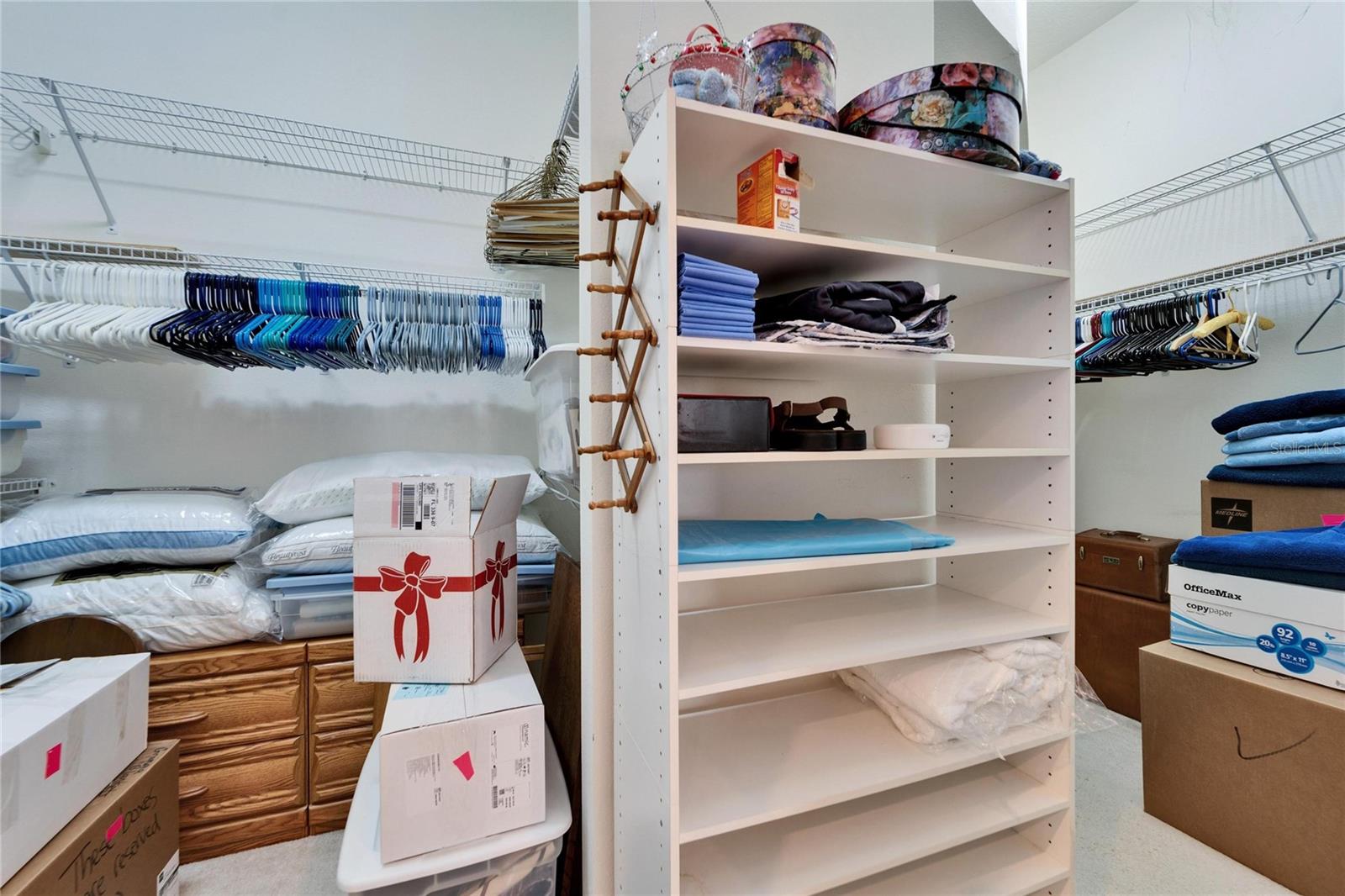 Walk in closet off the primary bathroom on the first floor. To the right is additional storage under the spiral staircase in the living room.