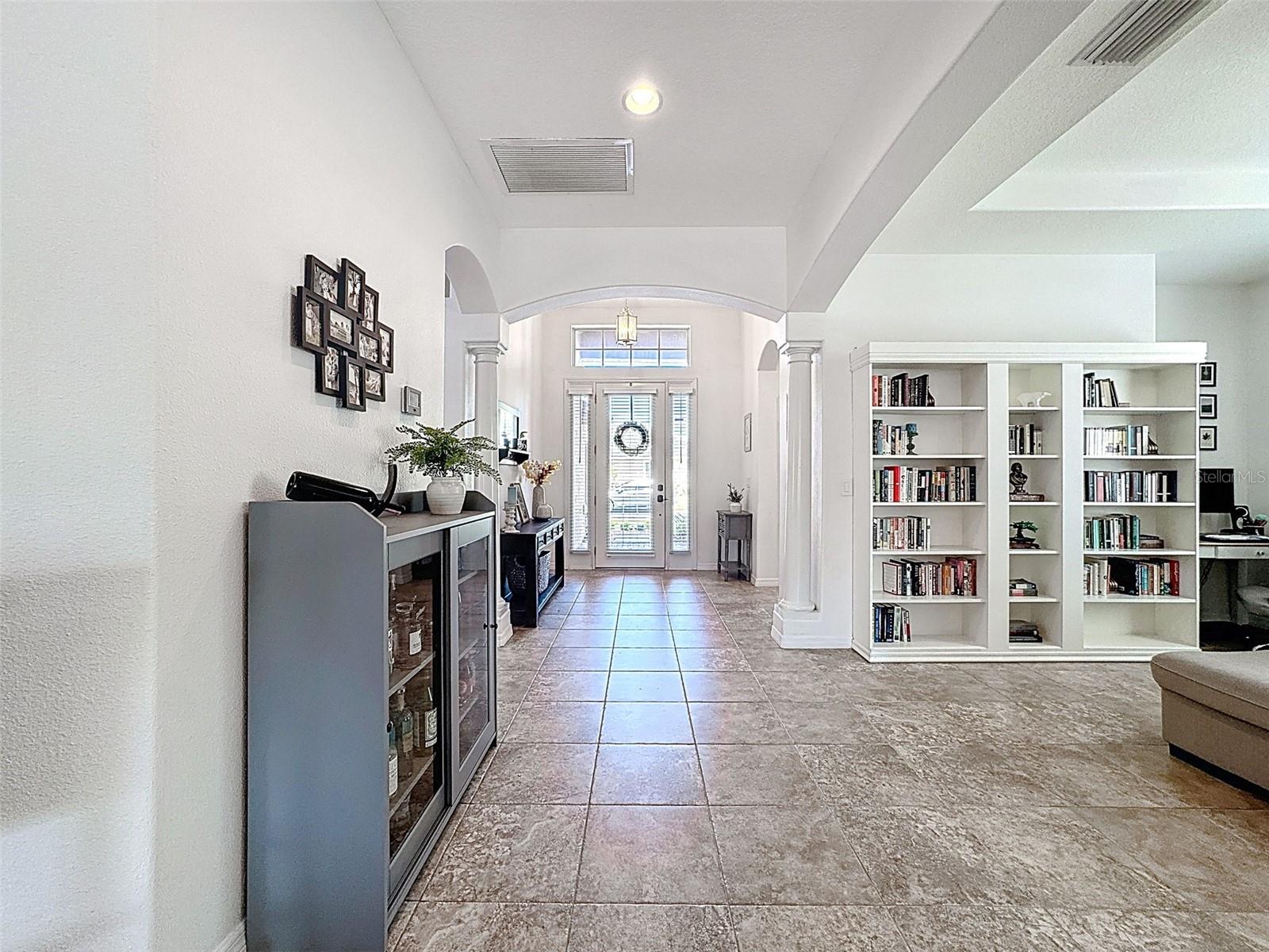 OPEN HALLWAY FROM FRONT WING OF THIS HOME TO ENTER THE GOURMET KITCHEN AND MAIN LIVING AREA