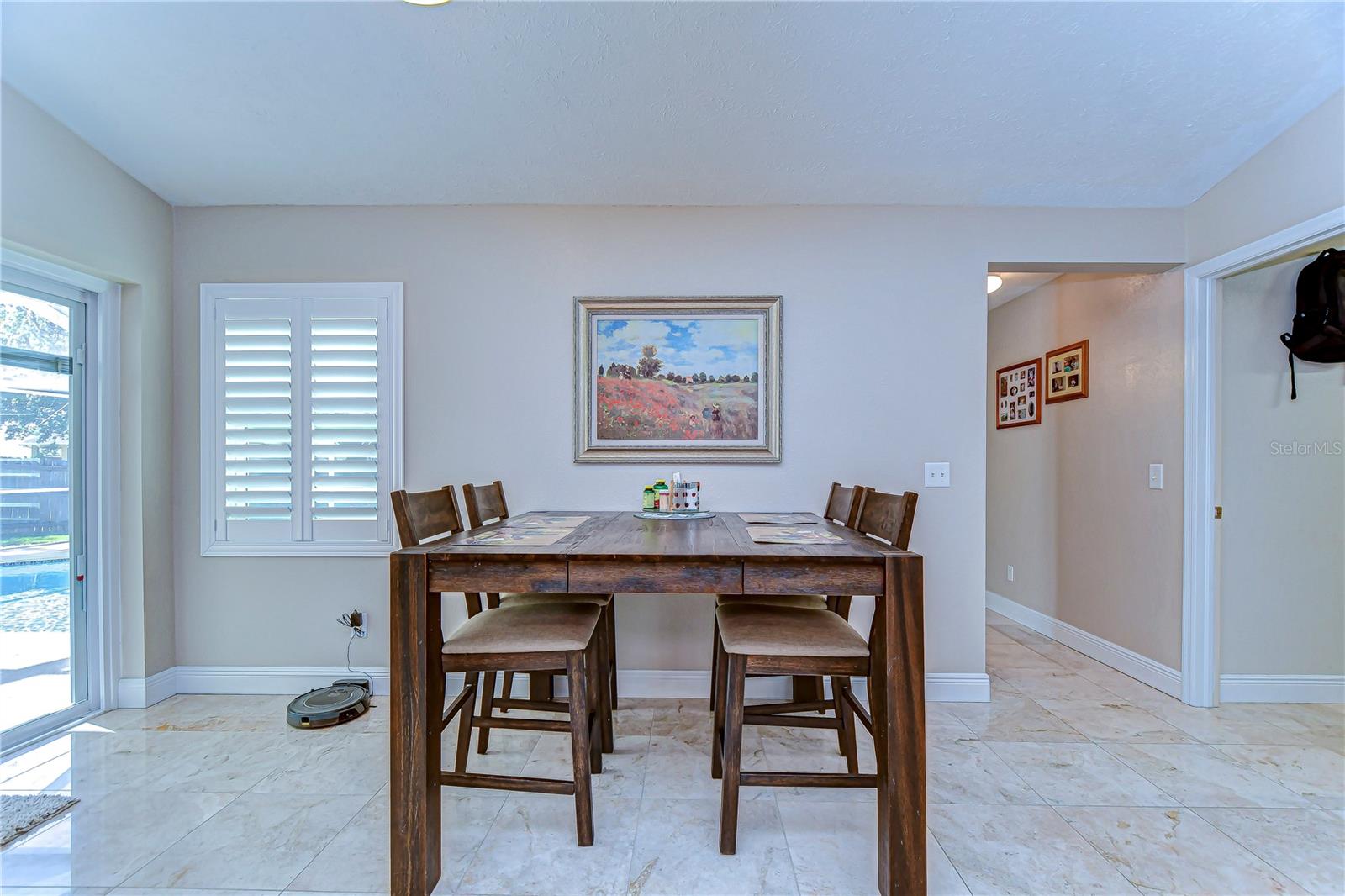 The elegant tile flooring complements the natural light pouring in, highlighting the warmth of this inviting dining nook.