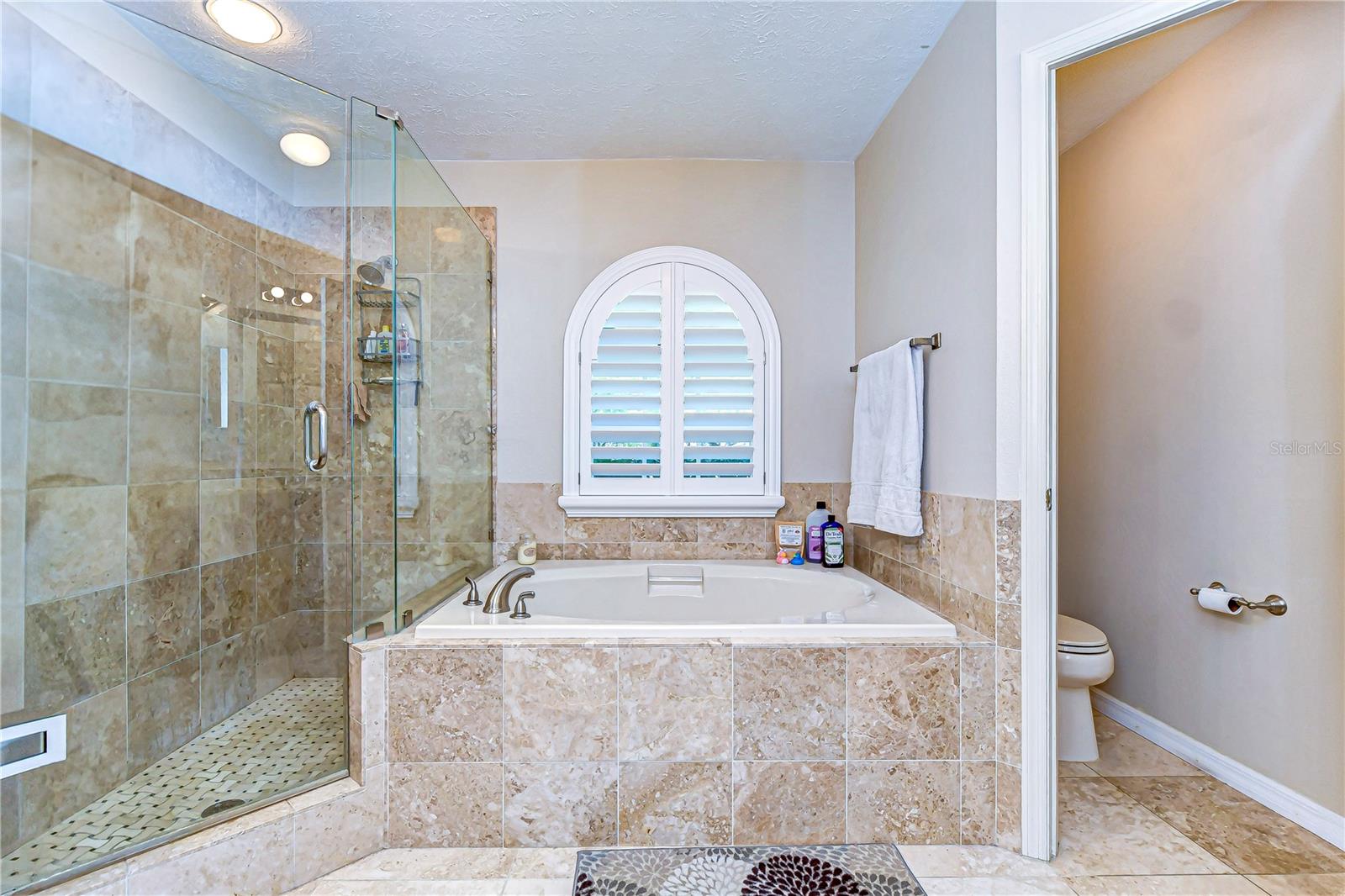 Unwind in style with this luxurious bathroom retreat featuring an elegant soaking tub and a spacious glass-enclosed shower