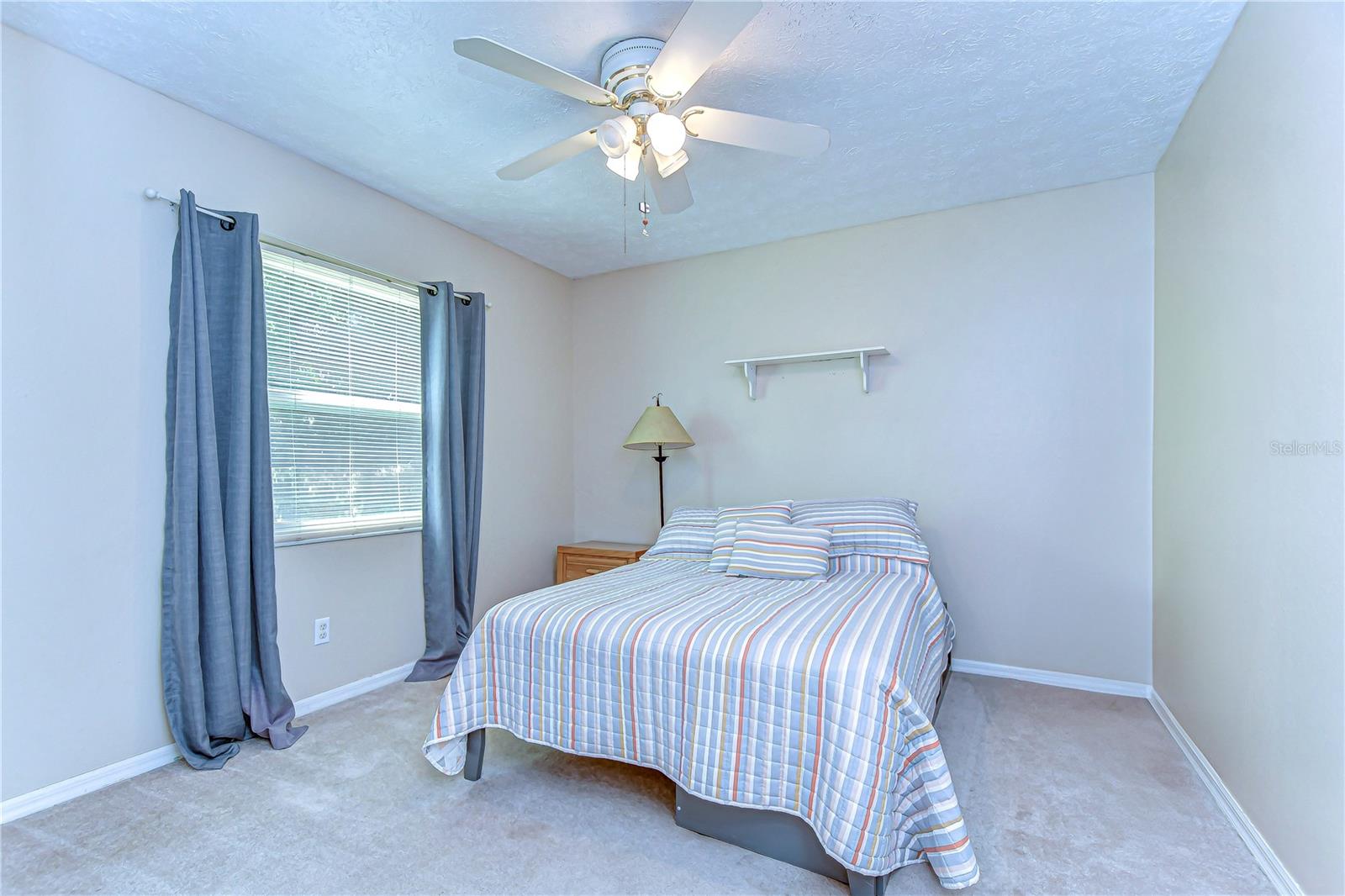 Cozy comfort meets functionality in this serene bedroom filled with natural light.