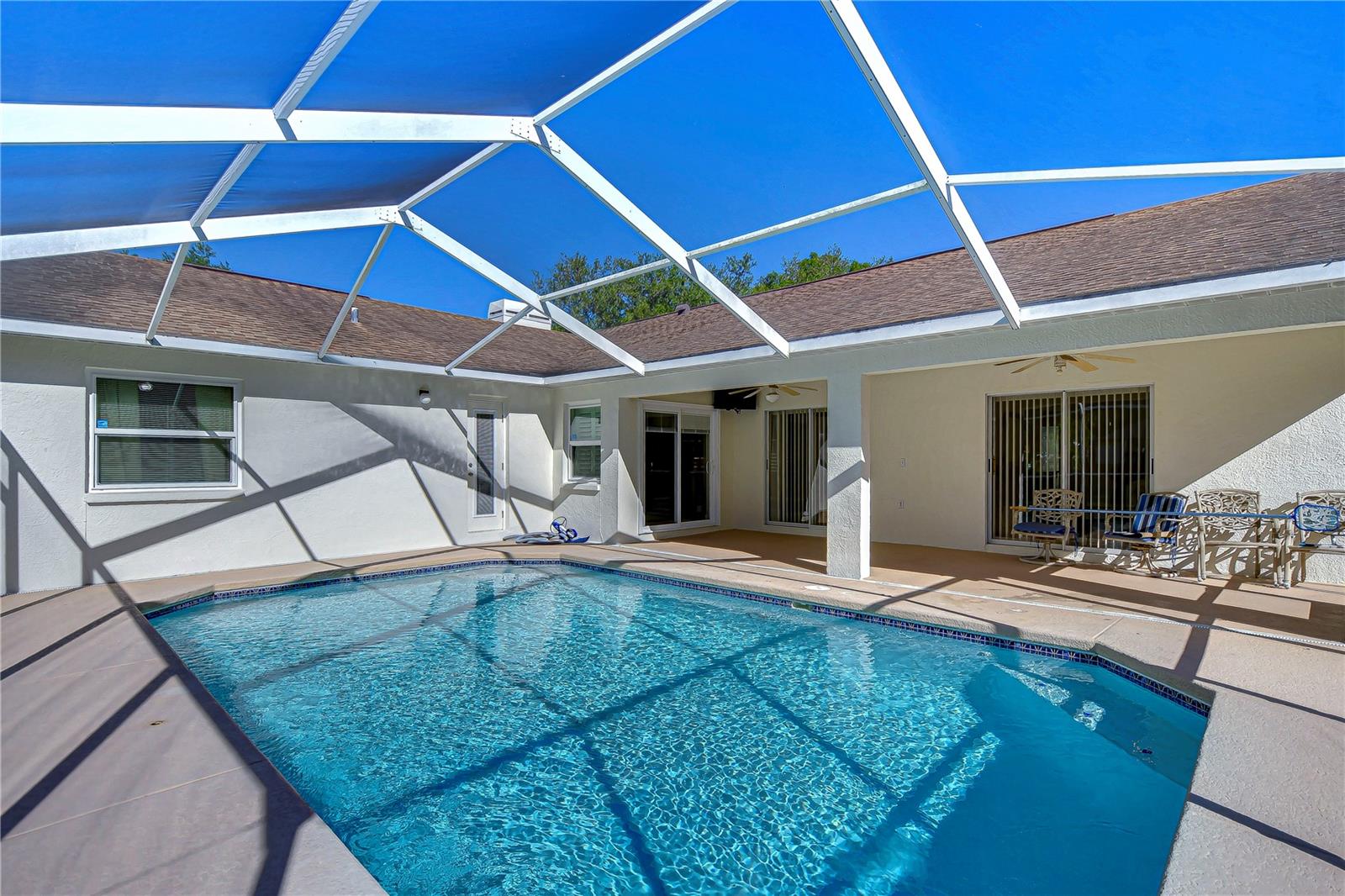 This sun-kissed, screened-in pool area is the ultimate spot for soaking up the Florida sun in style.